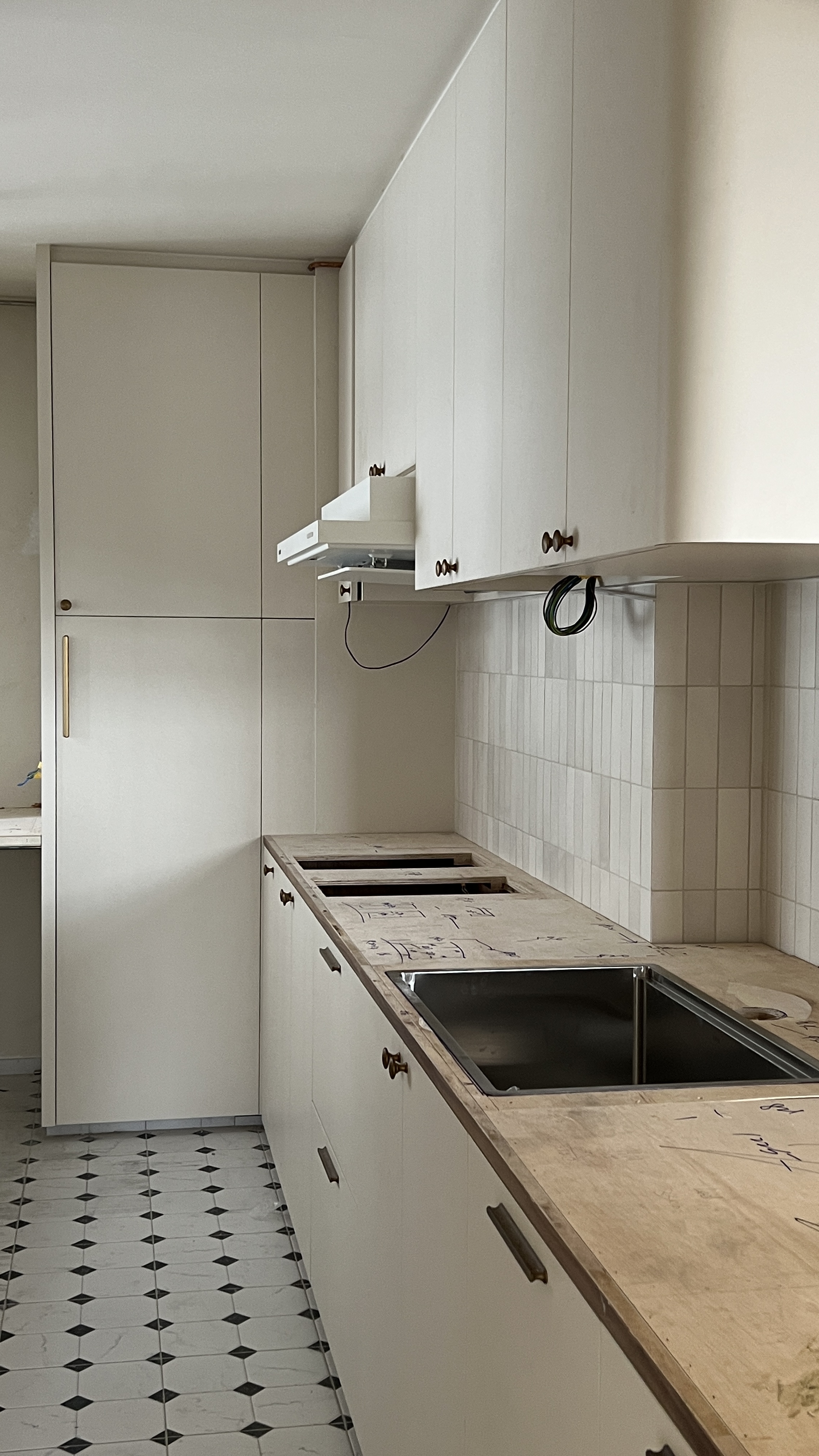 Our Kitchen: Soft Palettes and Clean Designs - White kitchen cabinets, tiled floor, black and white pattern, wooden