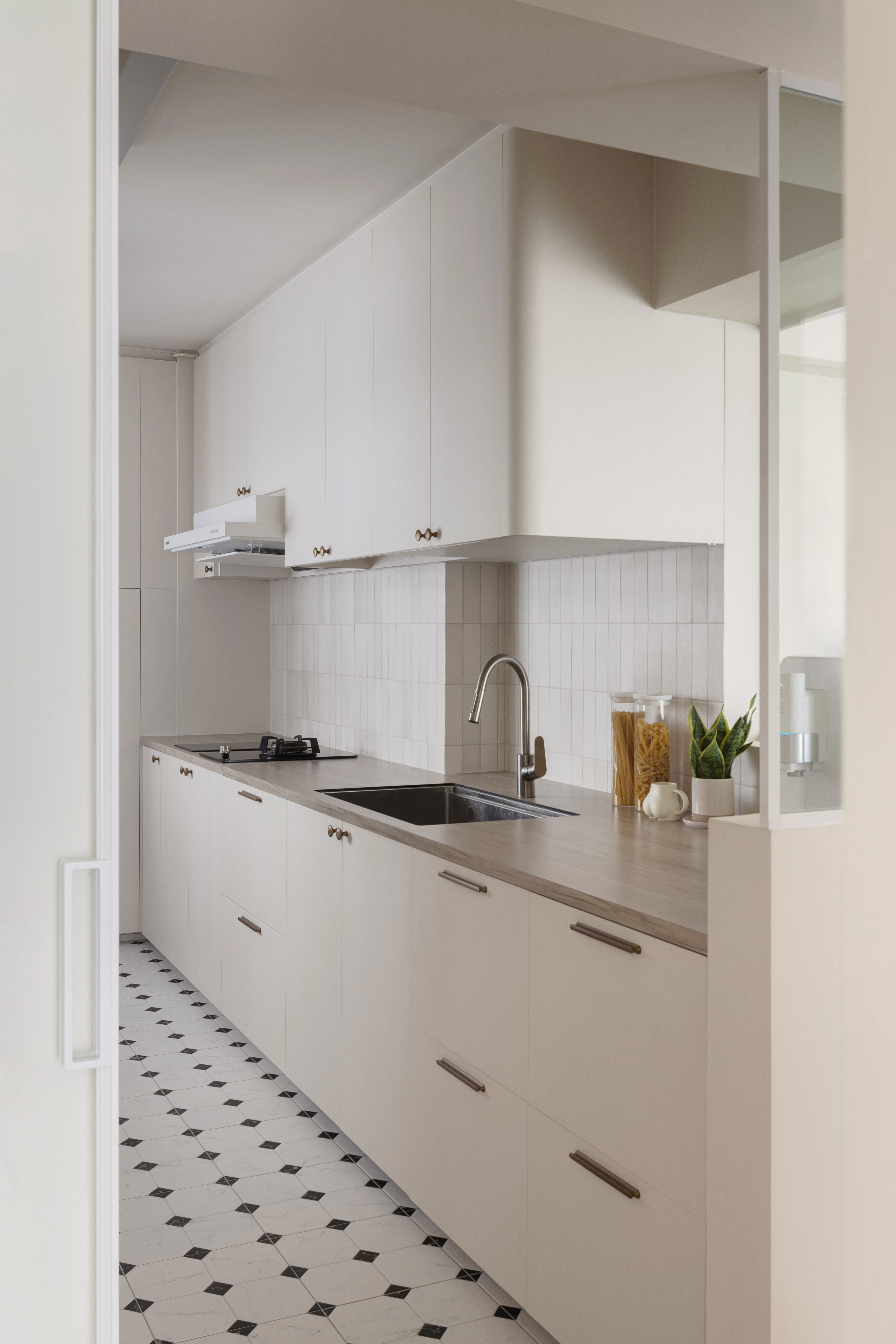 Our Kitchen: Soft Palettes and Clean Designs - Modern kitchen with white cabinets, stainless steel sink, black stove, tiled