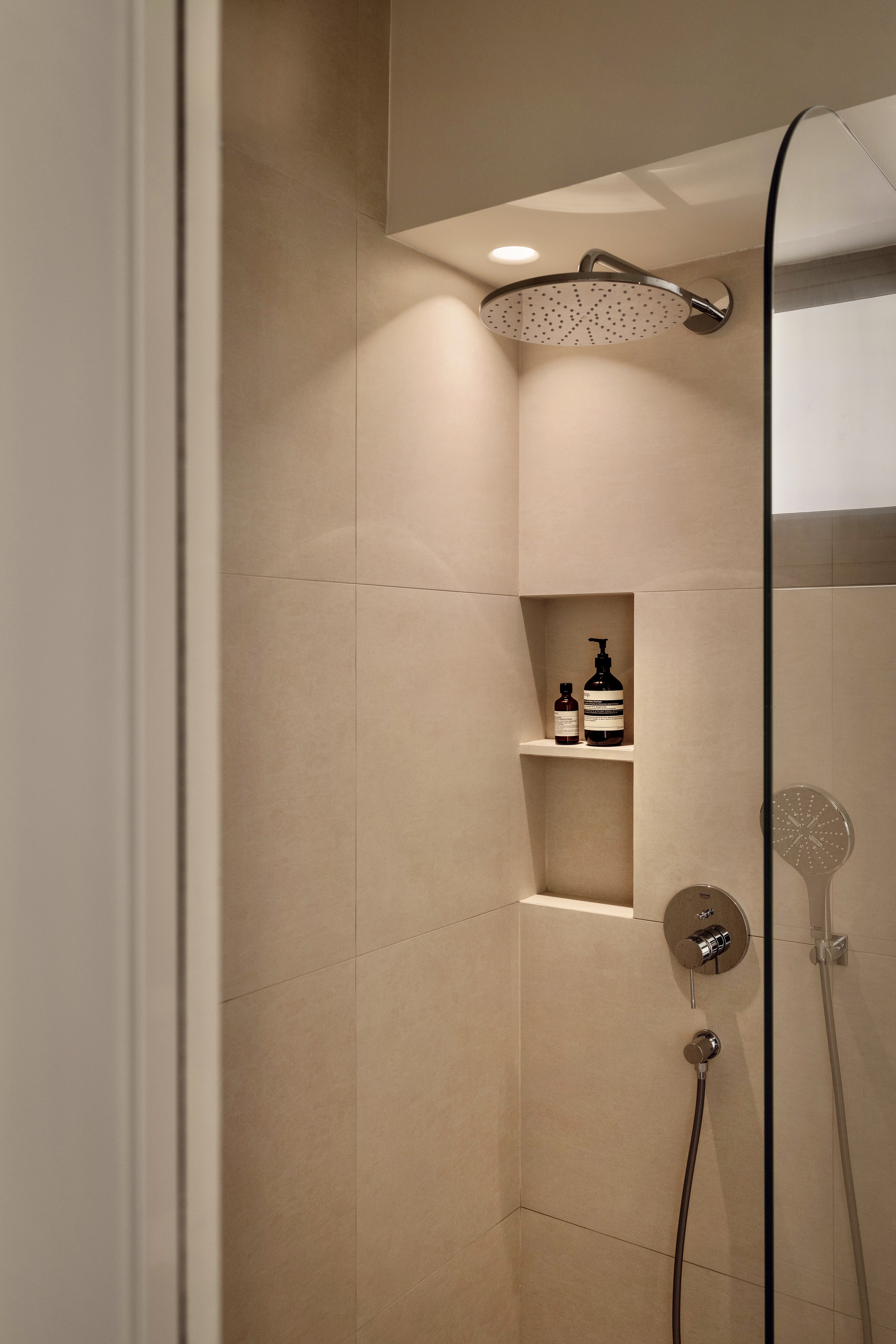 Creating A Soft Toned Master Bathroom - Modern minimalist bathroom, beige tiles, sleek showerhead, glass shower door