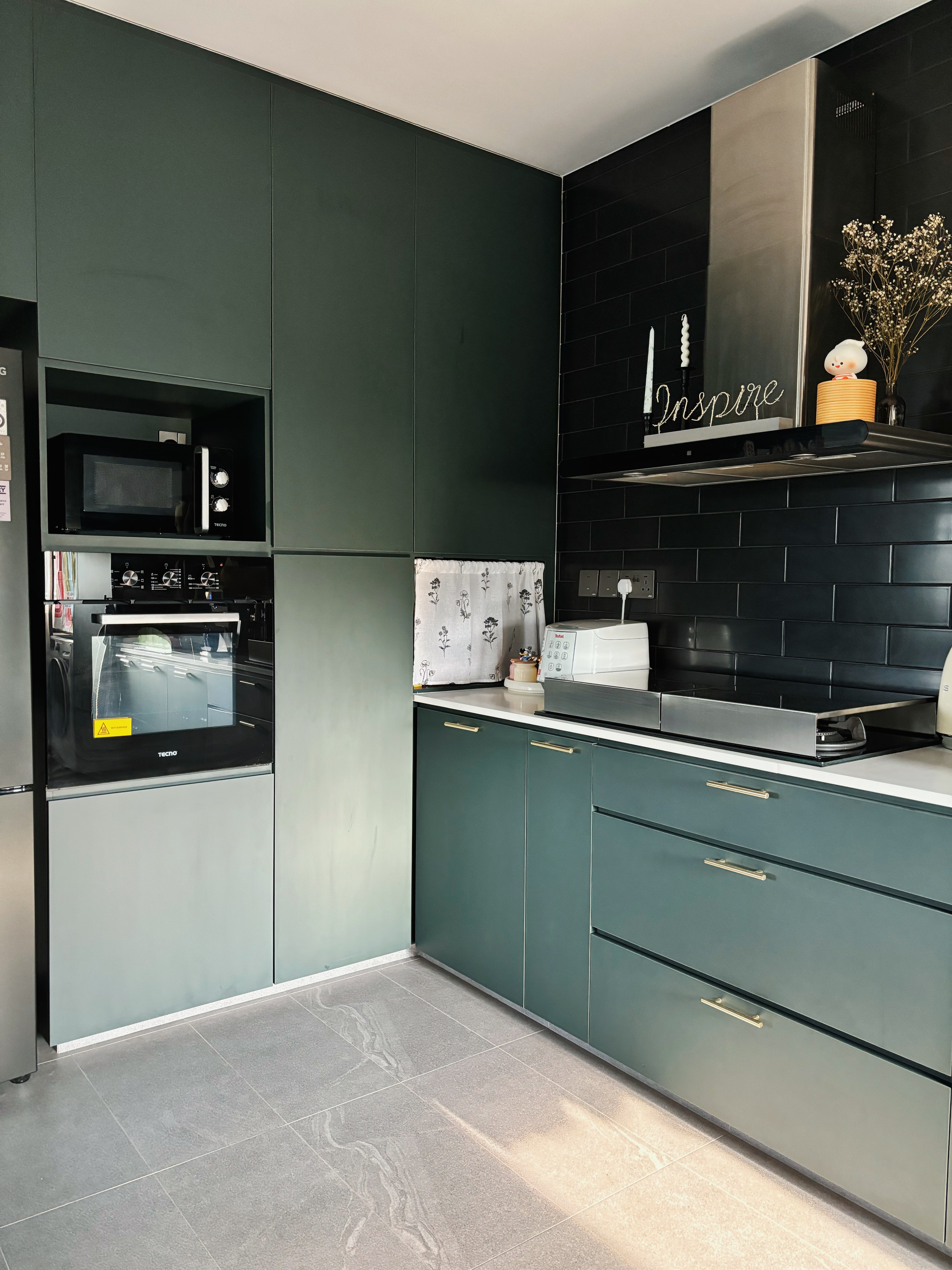 Our Kitchen Recipe - Modern kitchen with sleek design, dark green cabinets, stainless steel appliances, black tiled