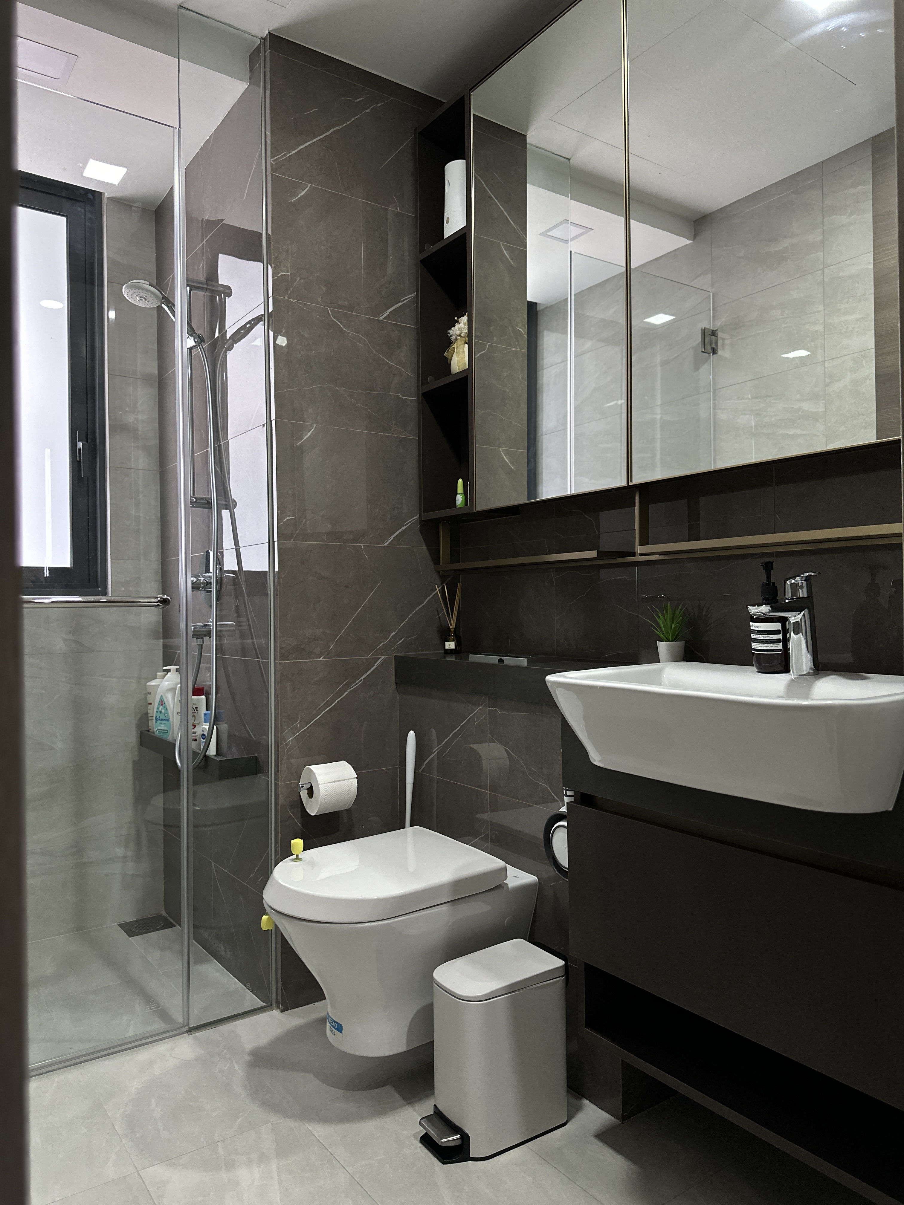 Minimalist Bathroom with a touch of mindfulness 🌿 - Modern bathroom with sleek design, dark marble tiles, glass shower