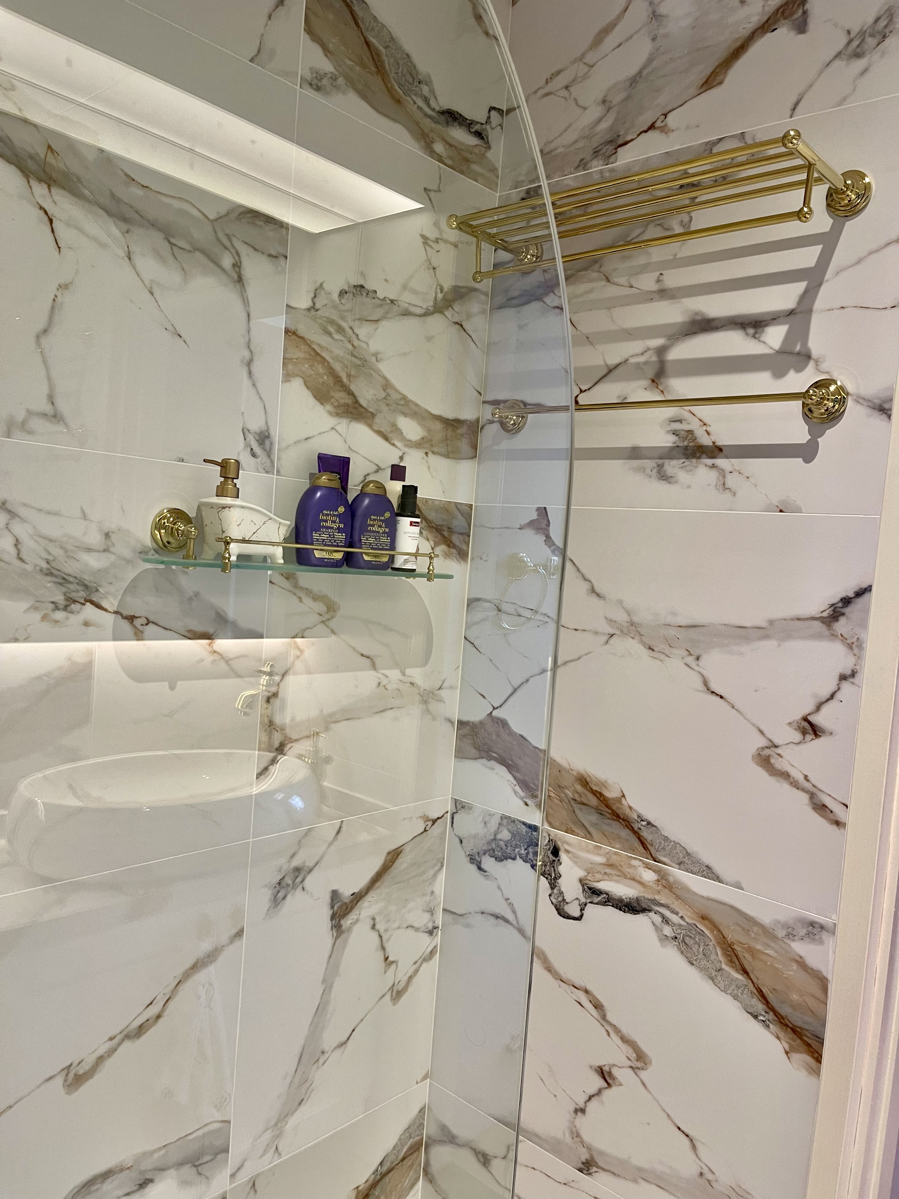 Our Bathroom Sanctuaries: A Concealed Luxe Master Ensuite VS Resort - Marble-patterned bathroom tiles, glass shower