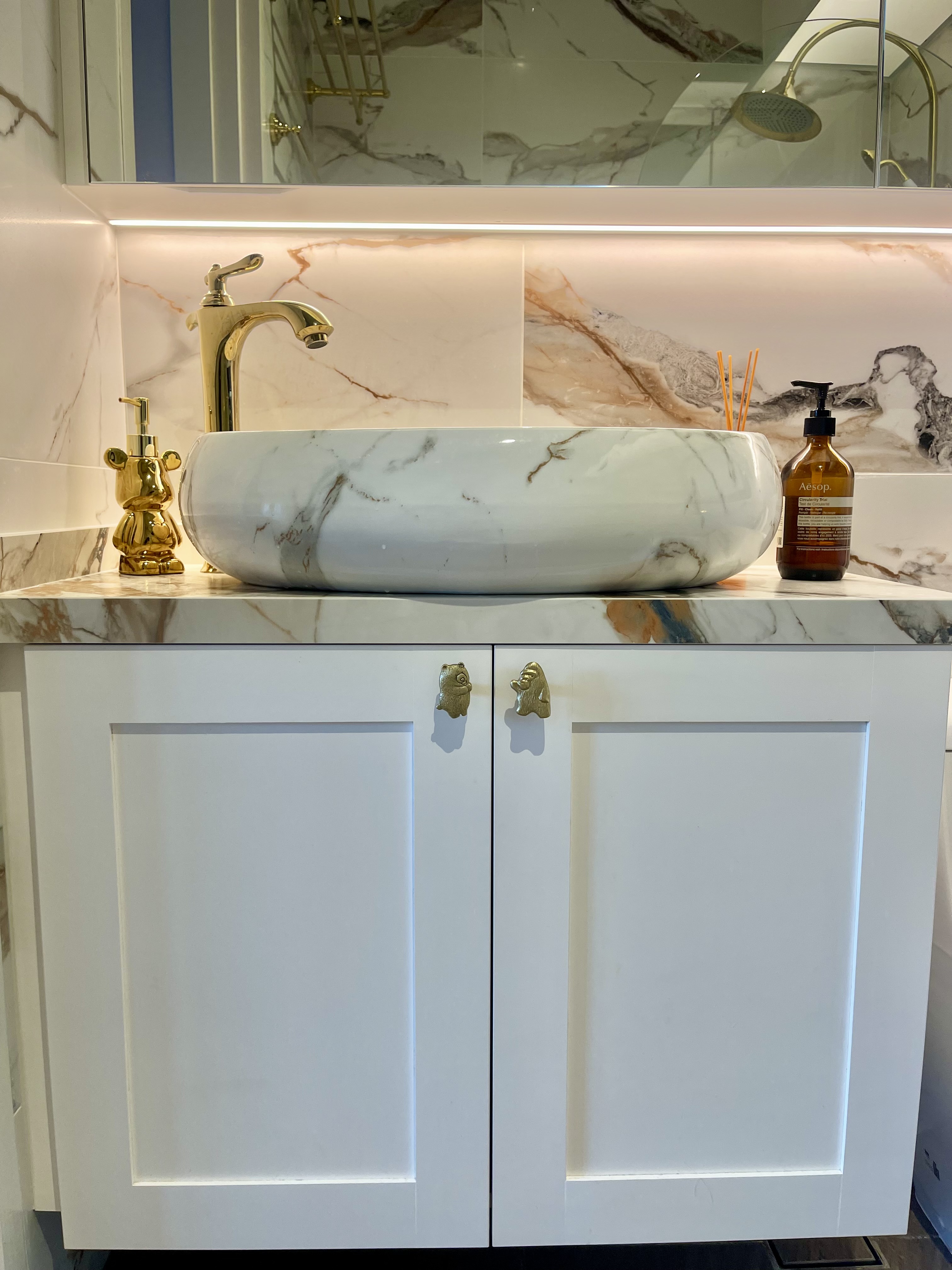 Our Bathroom Sanctuaries: A Concealed Luxe Master Ensuite VS Resort - Marble countertop, gold faucet, white sink, elegant