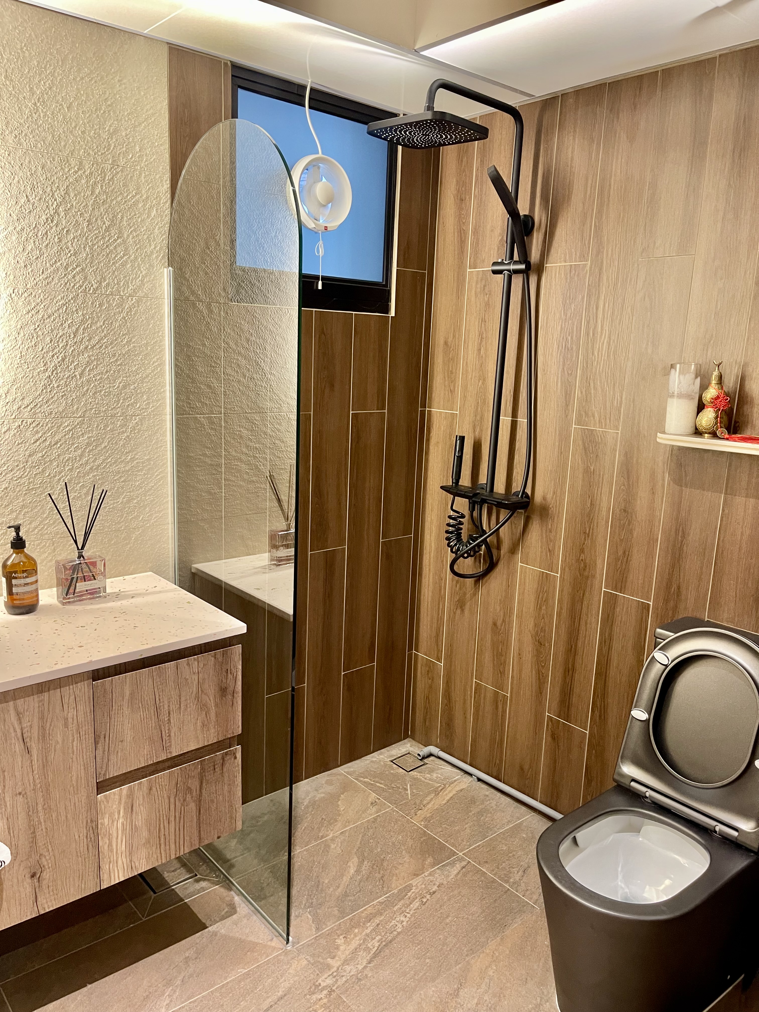 Our Bathroom Sanctuaries: A Concealed Luxe Master Ensuite VS Resort - Wooden vanity, glass shower door, black showerhead