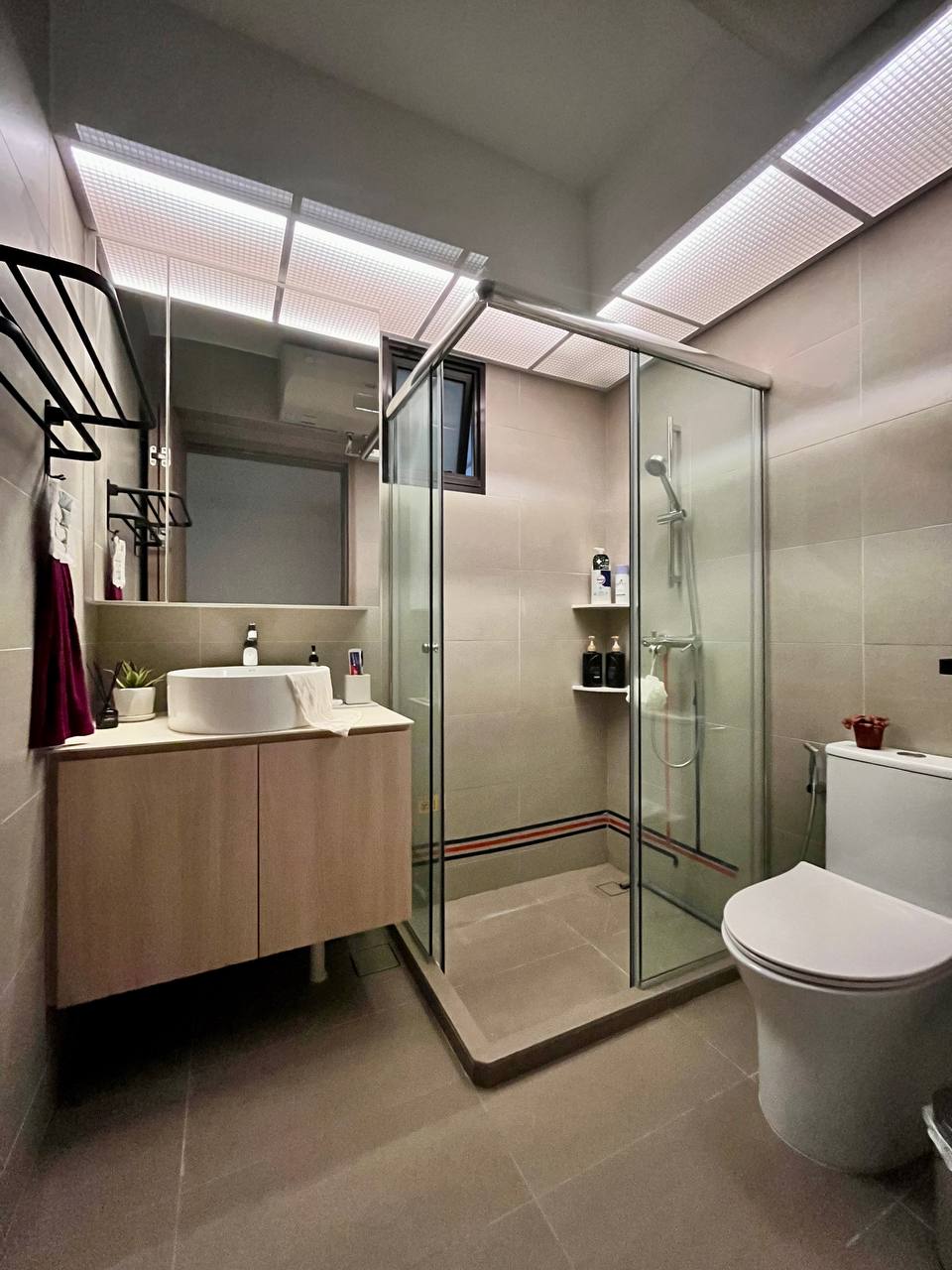 Toilet / Bathroom: Practicality Over Style on a Budget - Modern bathroom with sleek design, beige tiles, glass shower