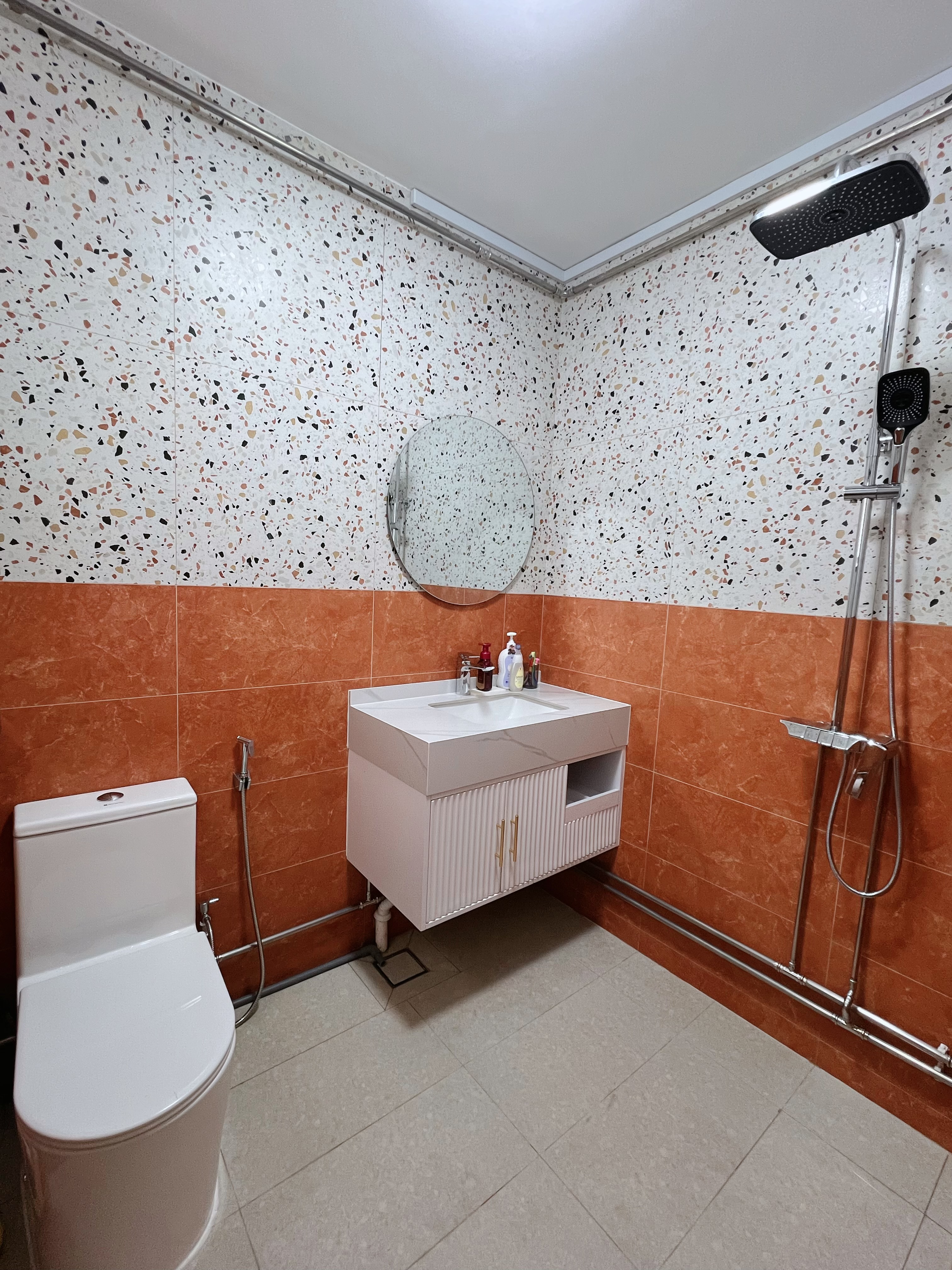 Tile Surprise: A perfect match found! - Modern bathroom with mosaic tile walls, white vanity with gold handles, white toilet