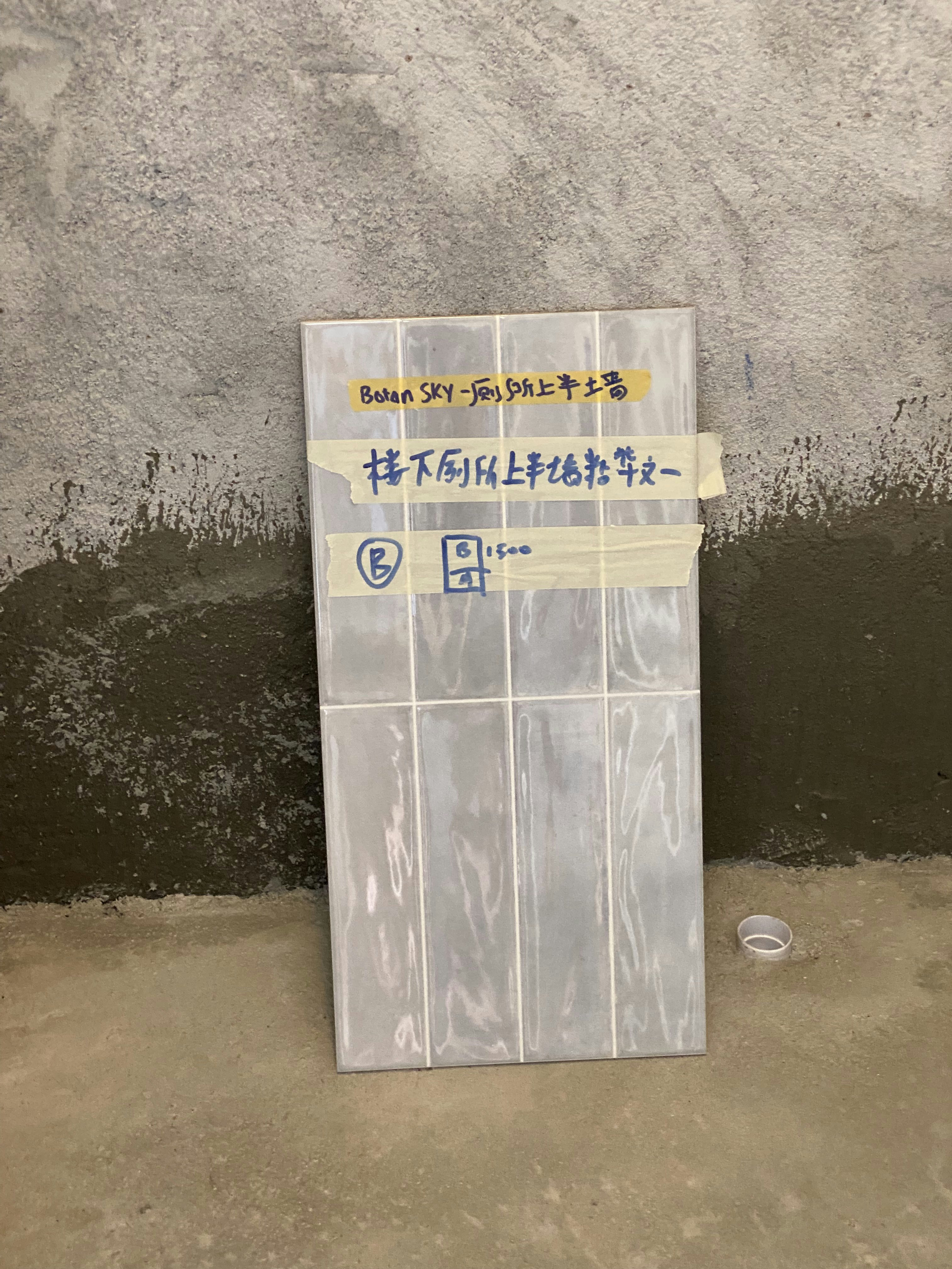 Tiny Guest Bathroom Redesign with Watercolor Blue and Grey Accents - Wall-mounted tile with Chinese labels, Concrete wall