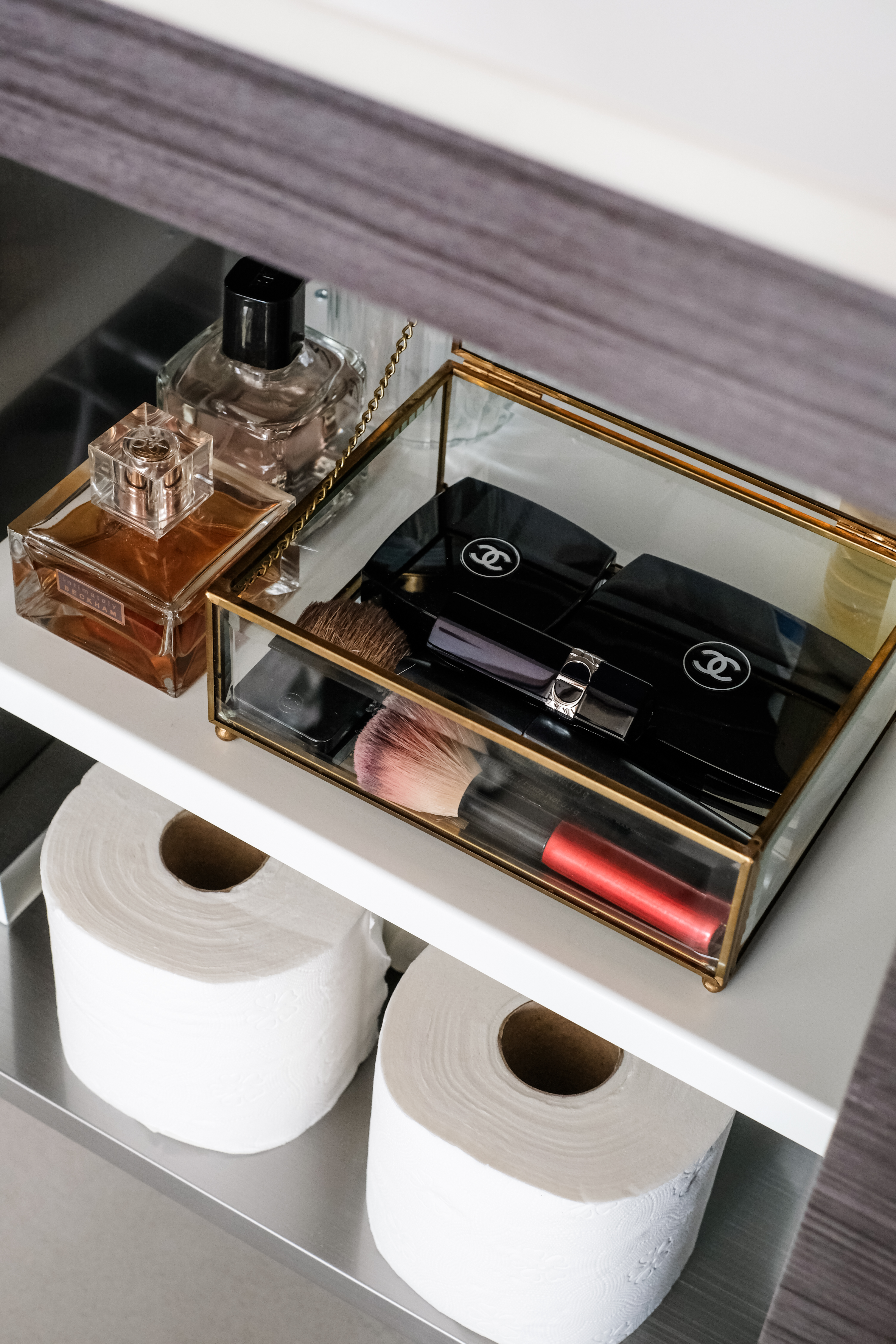 Sunlit Elegance: A Modern Bathroom Designed for Timeless Durability - Clear glass perfume bottle, gold chain, white