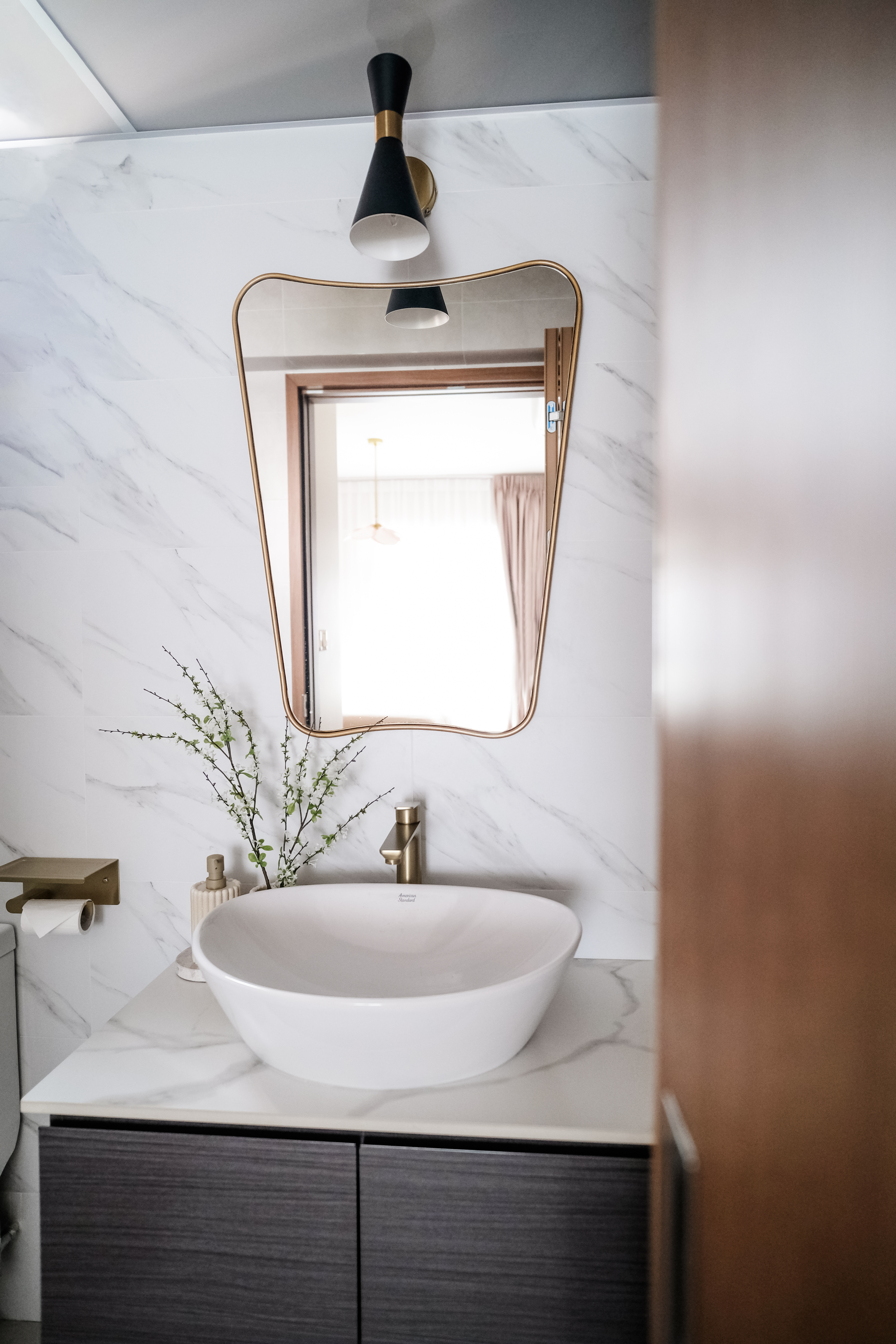 Sunlit Elegance: A Modern Bathroom Designed for Timeless Durability - White marble wall, modern bathroom, gold fixtures