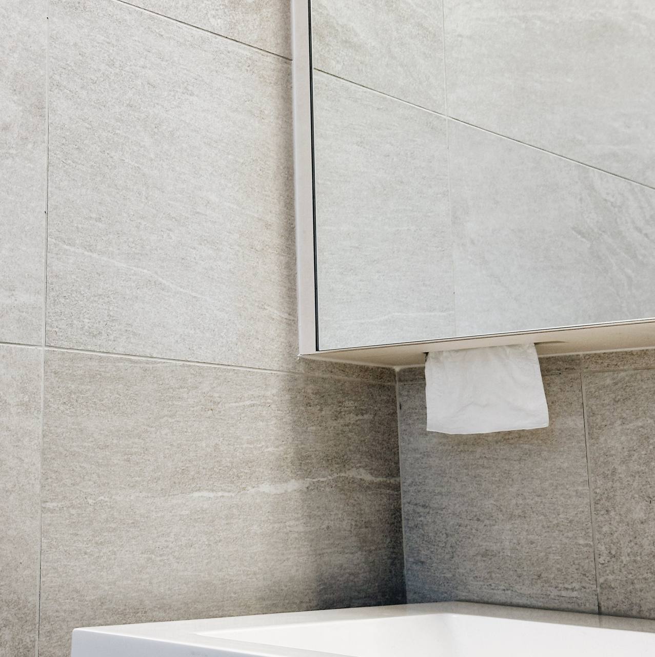 Our Master Bathroom: Fluted mirror storage cabinet!  - Light gray stone tiles, modern bathroom vanity, white countertop
