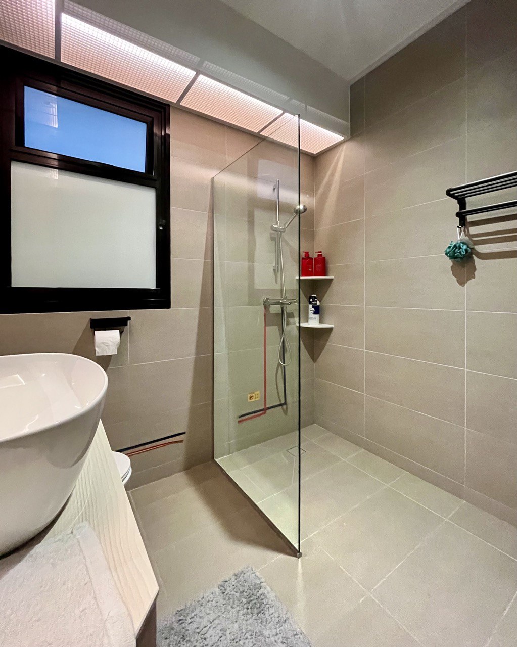 Toilet / Bathroom: Practicality Over Style on a Budget - Glass-enclosed shower, beige tiled walls, modern design, white sink
