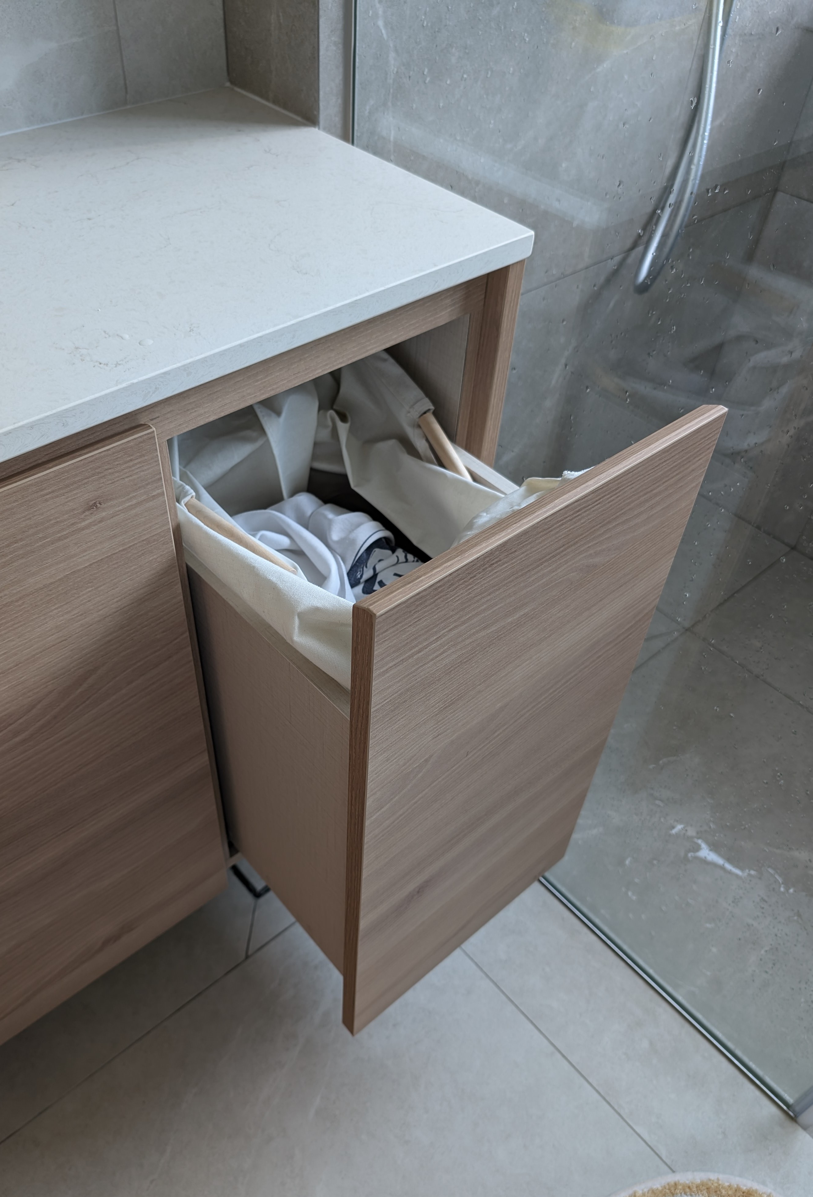 We had a bathtub but dumped it! 🛁 - Wooden cabinet, open drawer, neatly folded clothes, tiled floor, modern bathroom, clean