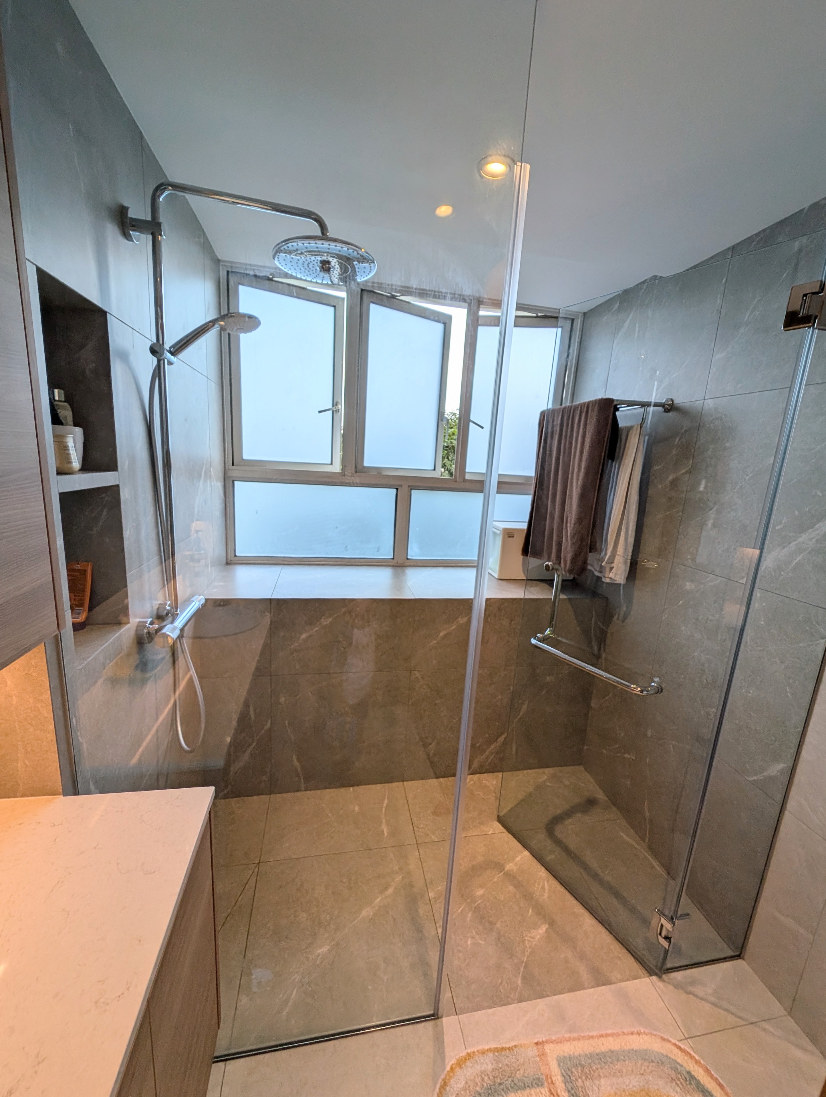 We had a bathtub but dumped it! 🛁 - Modern bathroom with glass shower enclosure, beige marble tiles, built-in shelves