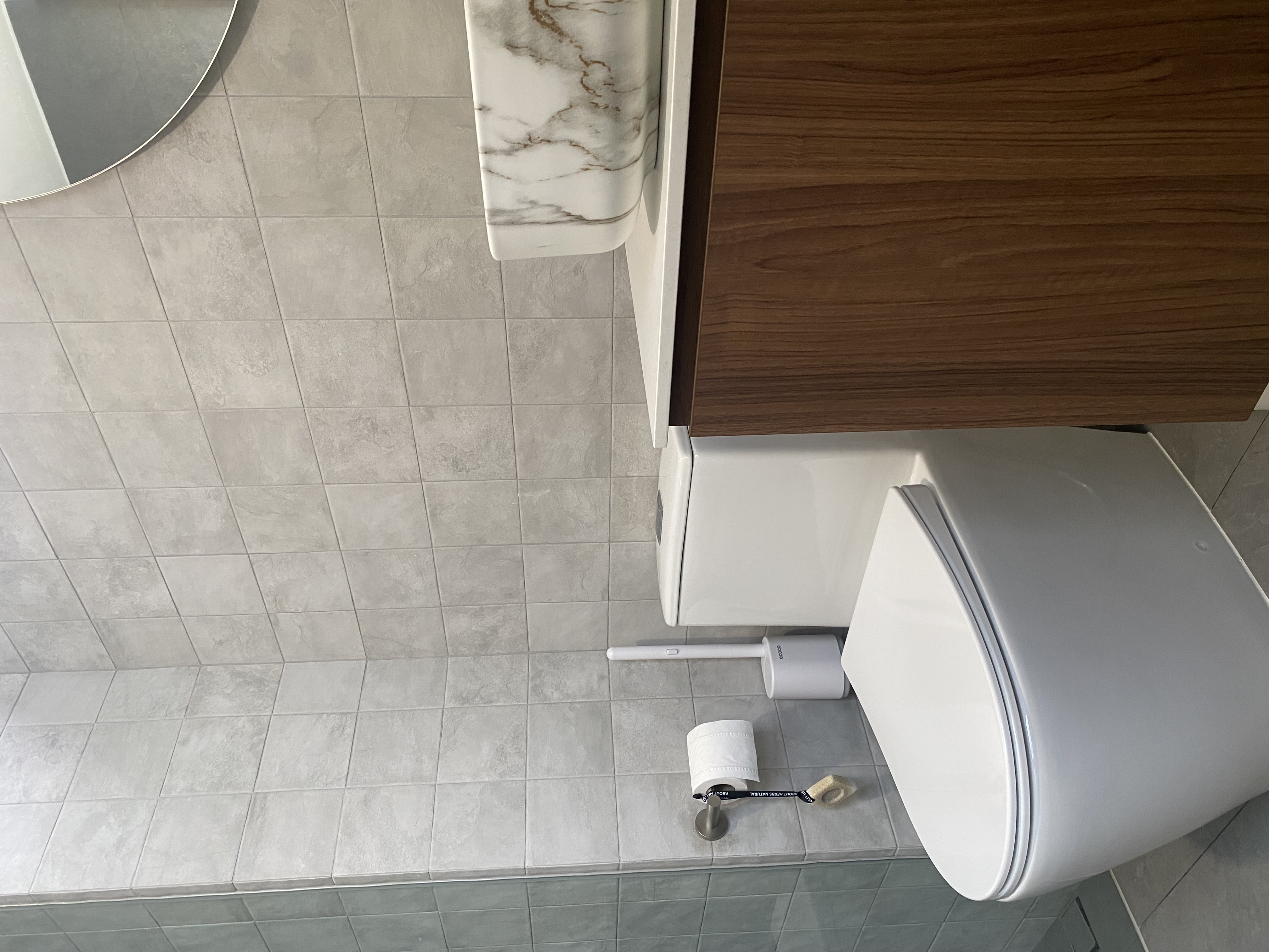 Moody and textured bathrooms in 50 shades of grey - Gray tiled bathroom floor, white toilet, wooden cabinet, white toilet