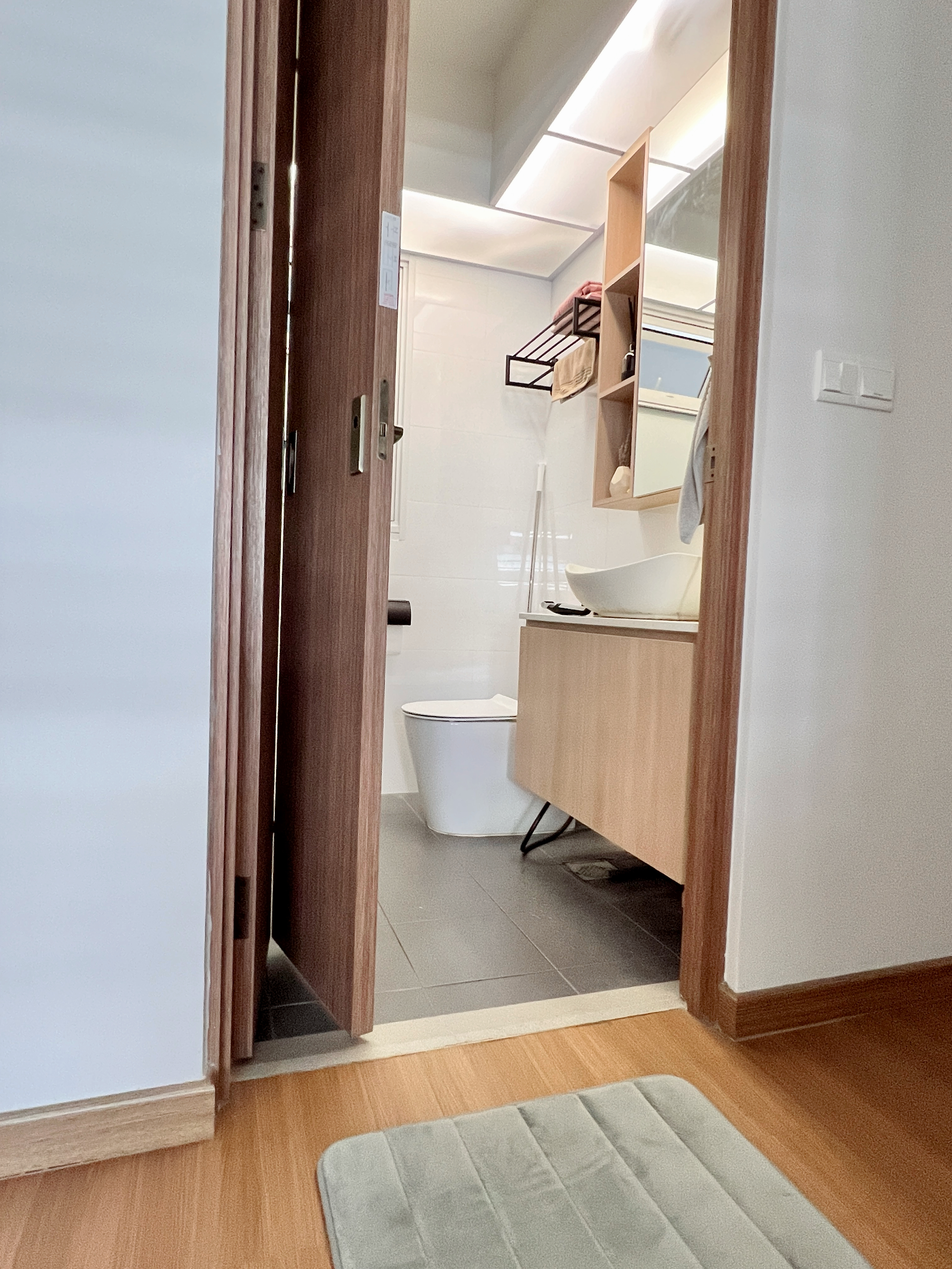 Budget Toilet Renovation Under $1K!! 🛀🏼 - Wooden door frame, modern bathroom, open doorway, light-colored walls, tiled