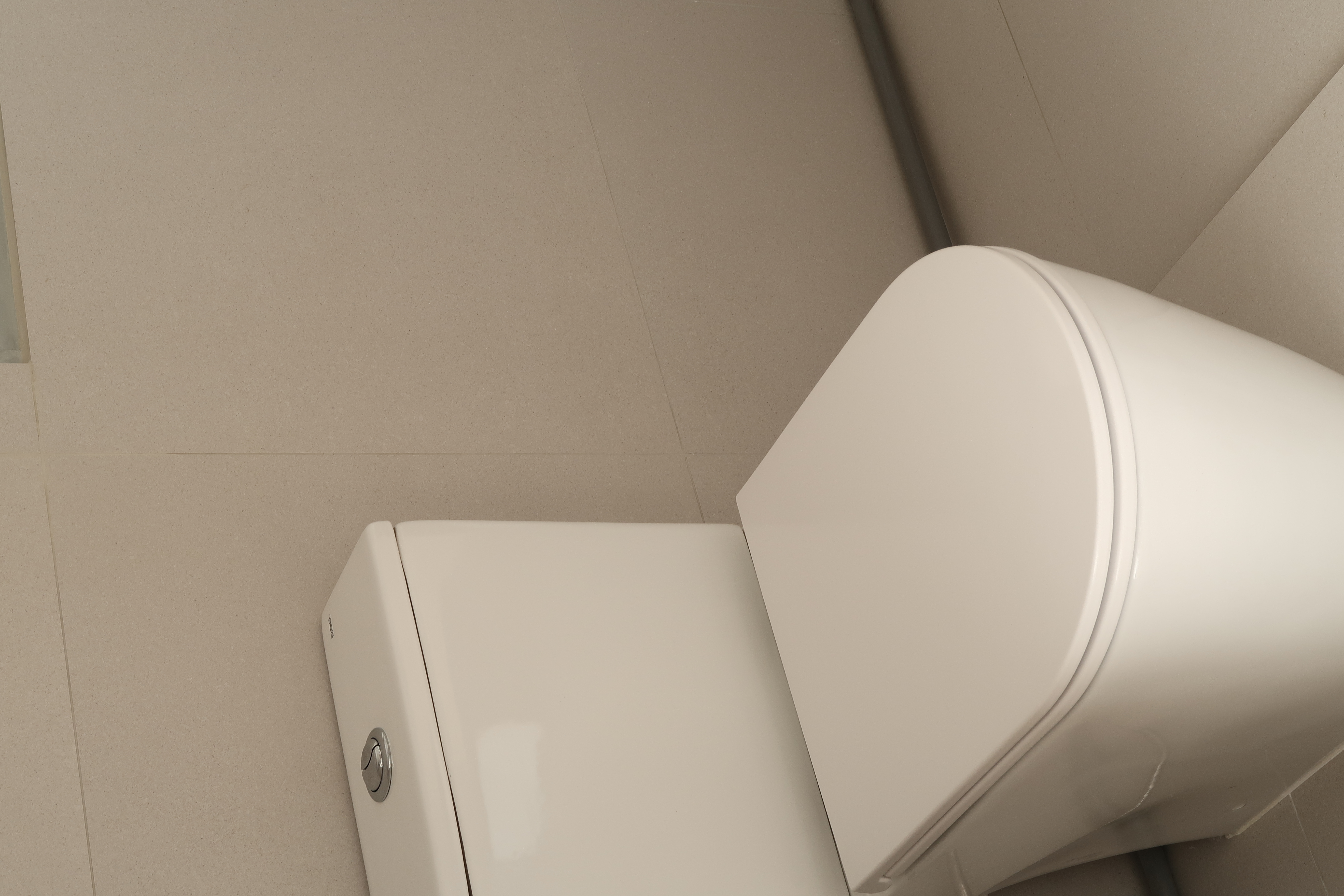 Guest Bathroom: Clean Lines and Subway Tiles - White toilet, beige tiled floor, modern design, sleek surface, minimalist