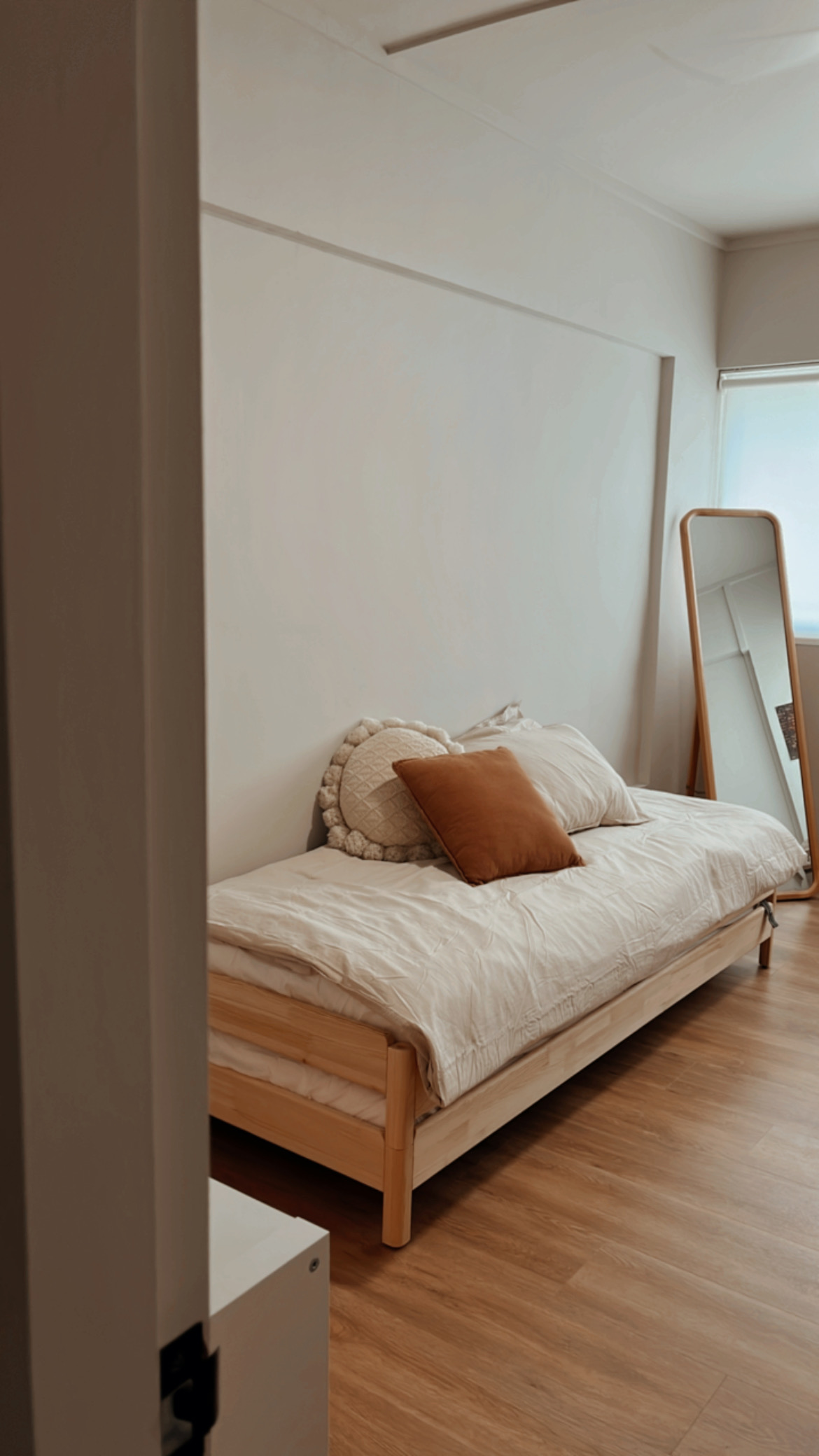 Creating the Perfect Guest Room: A Blend of Comfort and Style - Wooden bed with beige bedding, brown pillow, white quilt
