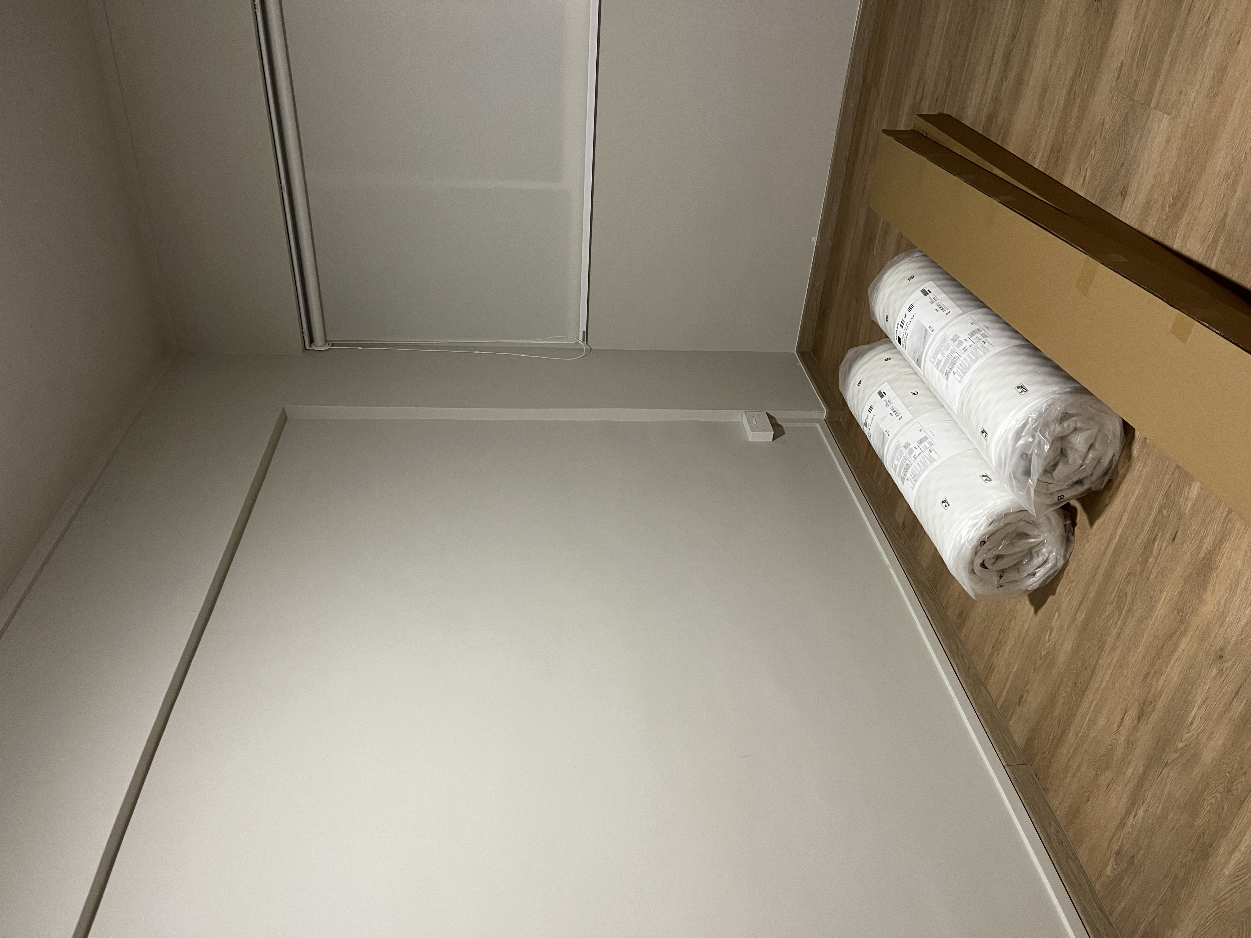 Creating the Perfect Guest Room: A Blend of Comfort and Style - White ceiling, wooden floor, neatly folded linens, cardboard