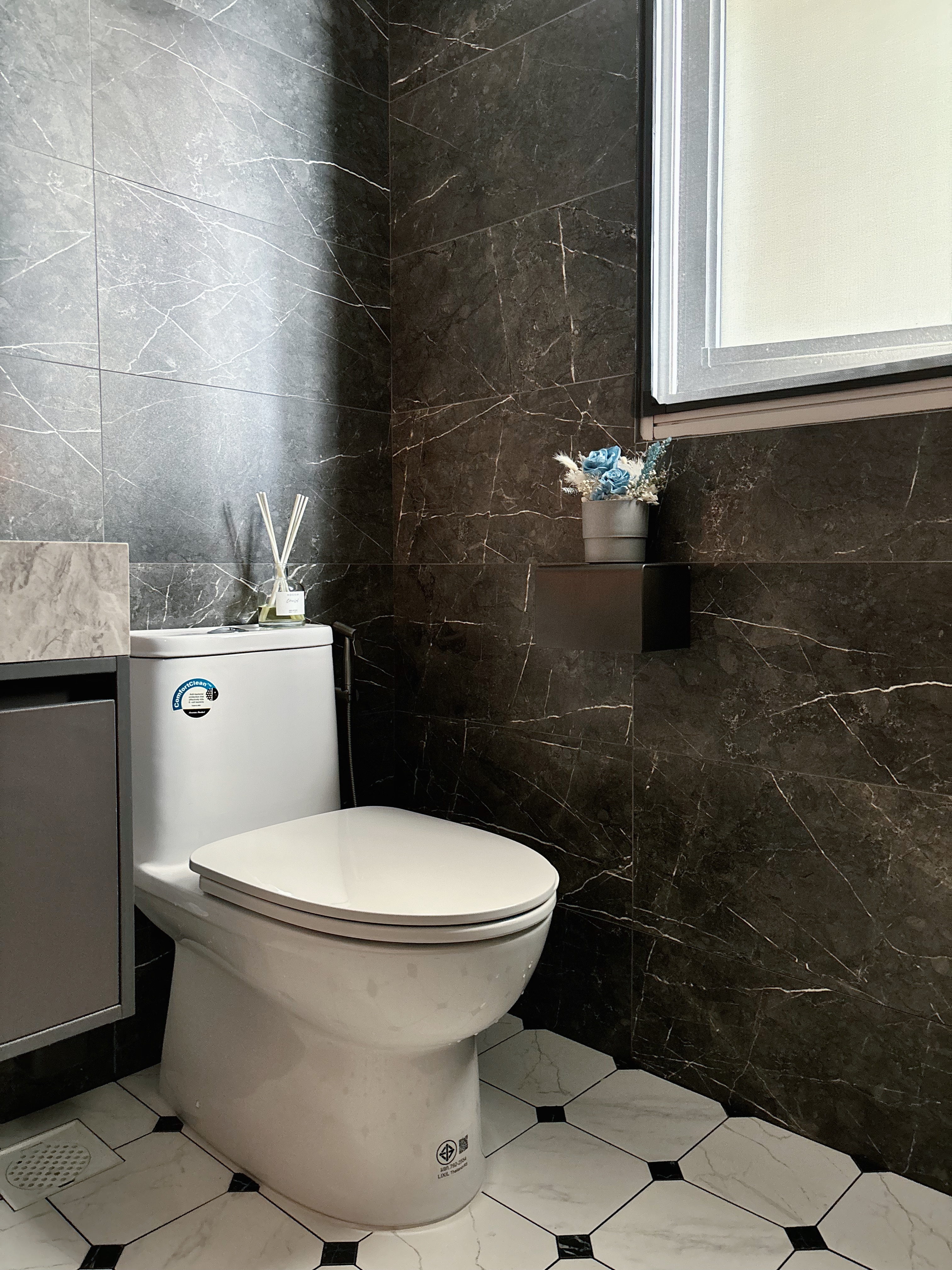 Refined and Modern: Our Master Bath Scene - Dark marble tiles, white toilet, black and white tiled floor, modern bathroom