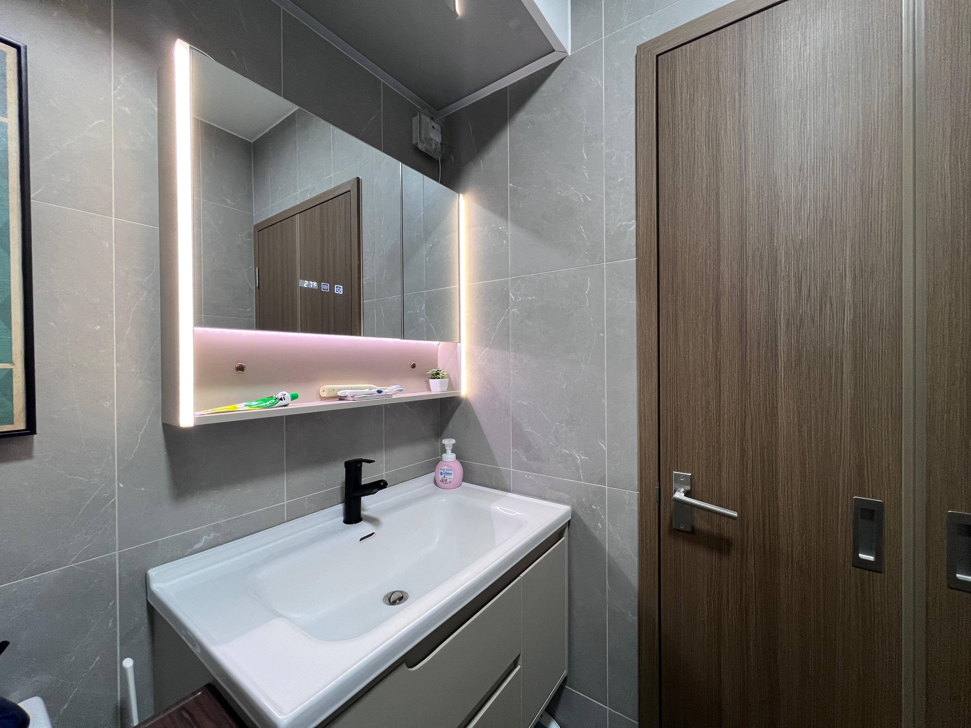 Simple and cost saving toilet - Modern bathroom vanity, sleek design, illuminated mirror, wooden door, gray tiled walls