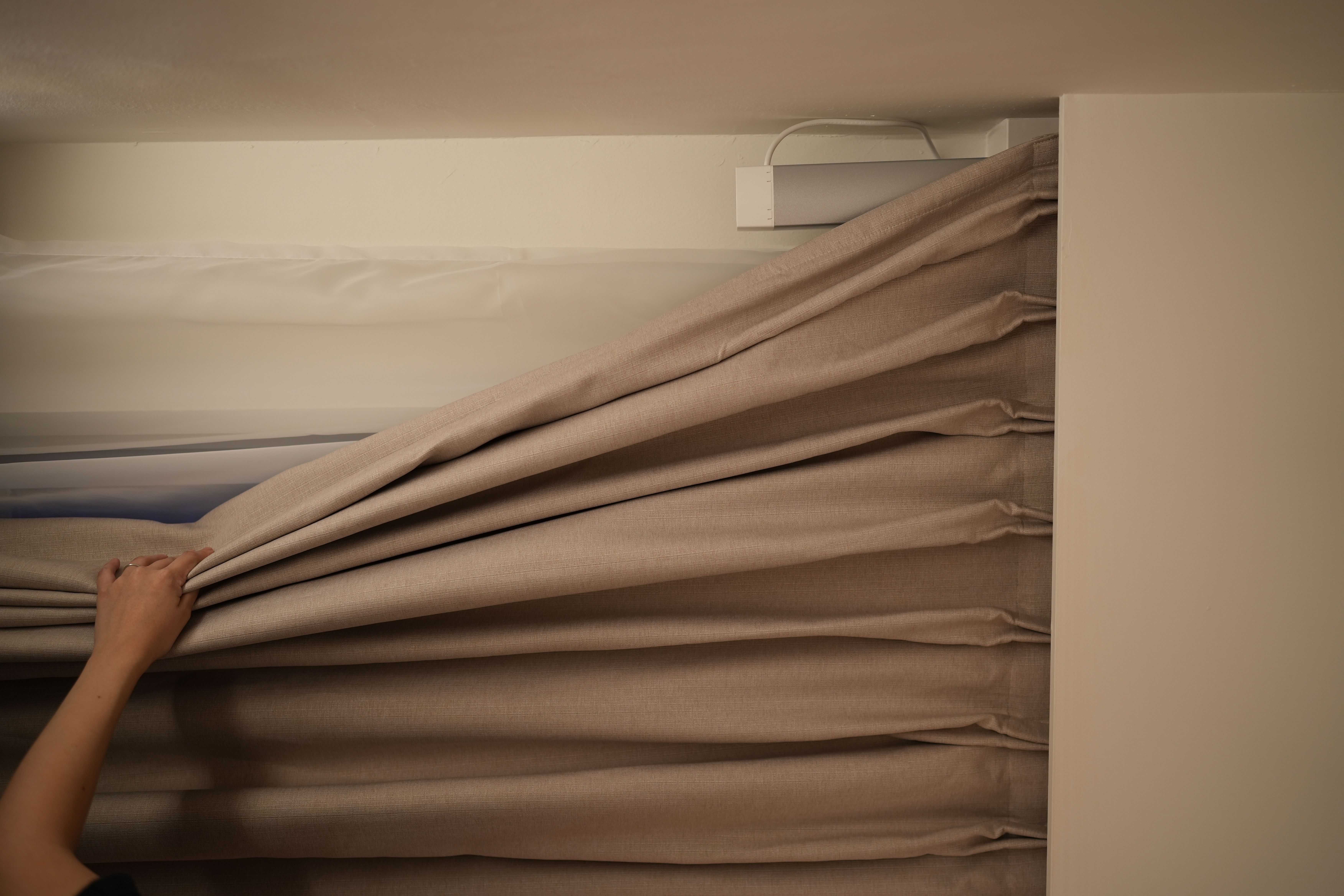 FAQ with @hitotema.home - Soft beige curtains, neatly folded, person adjusting, light beige wall, minimalist bedroom, cozy