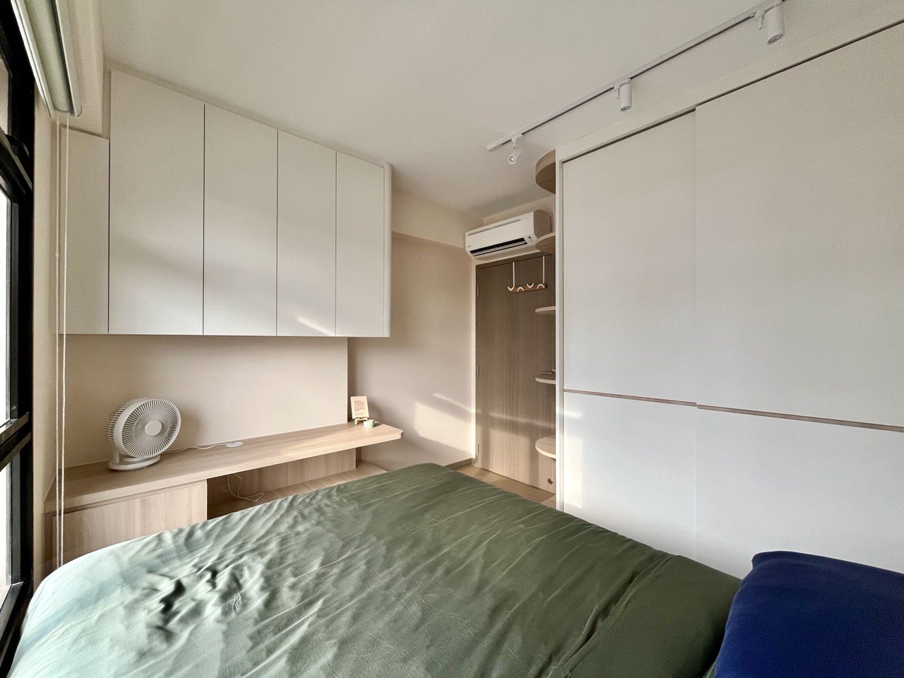 Common Room: A Sense of Hygge Retreat  - White cabinetry, minimalist design, integrated shelving, wooden desk, fan, natural