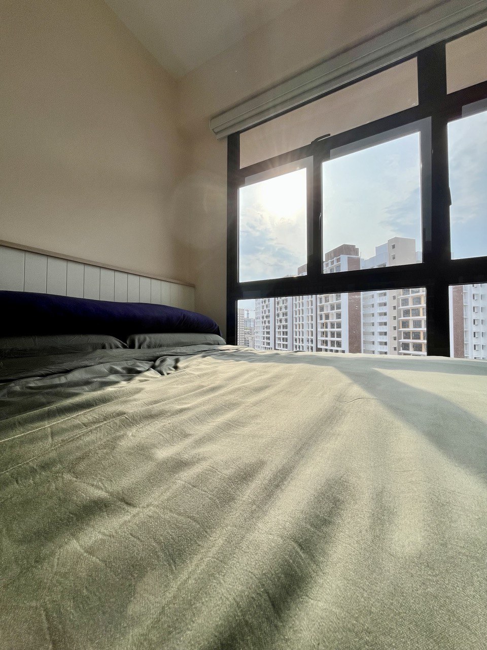 Common Room: A Sense of Hygge Retreat  - Sunlight streaming through large window, soft shadows on bed, cityscape view, modern