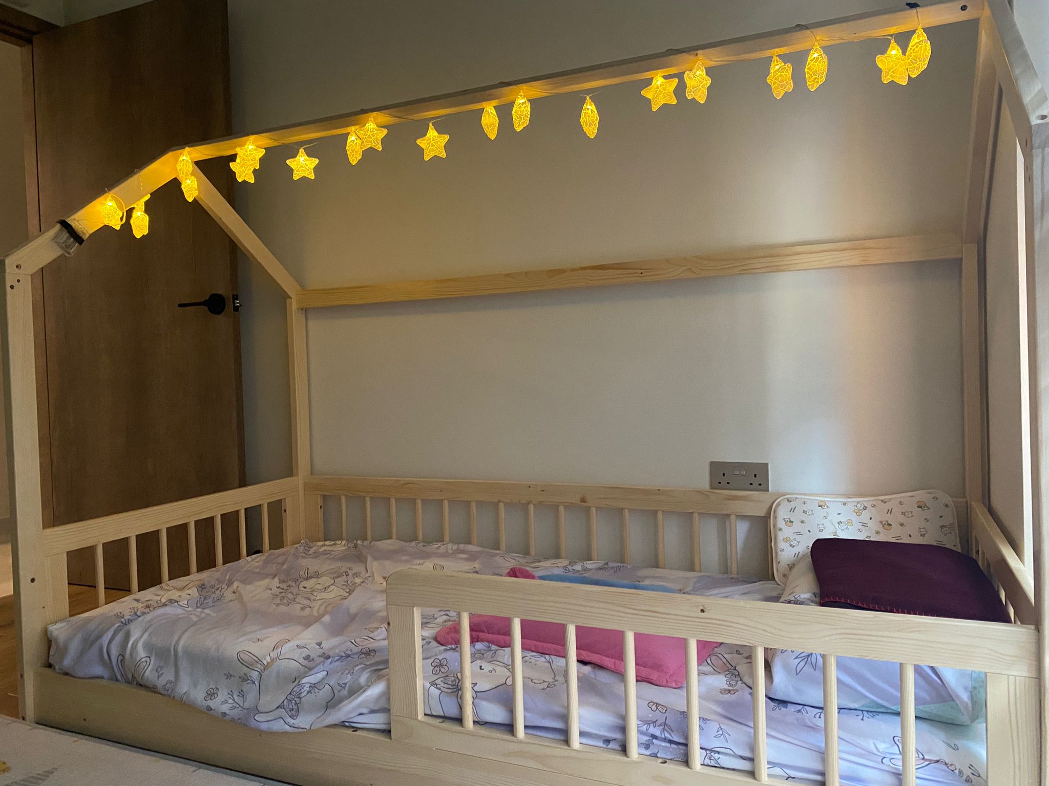 My son's room: Montessori concept where less is more - Wooden crib with soft bedding, pastel-colored pattern, decorative