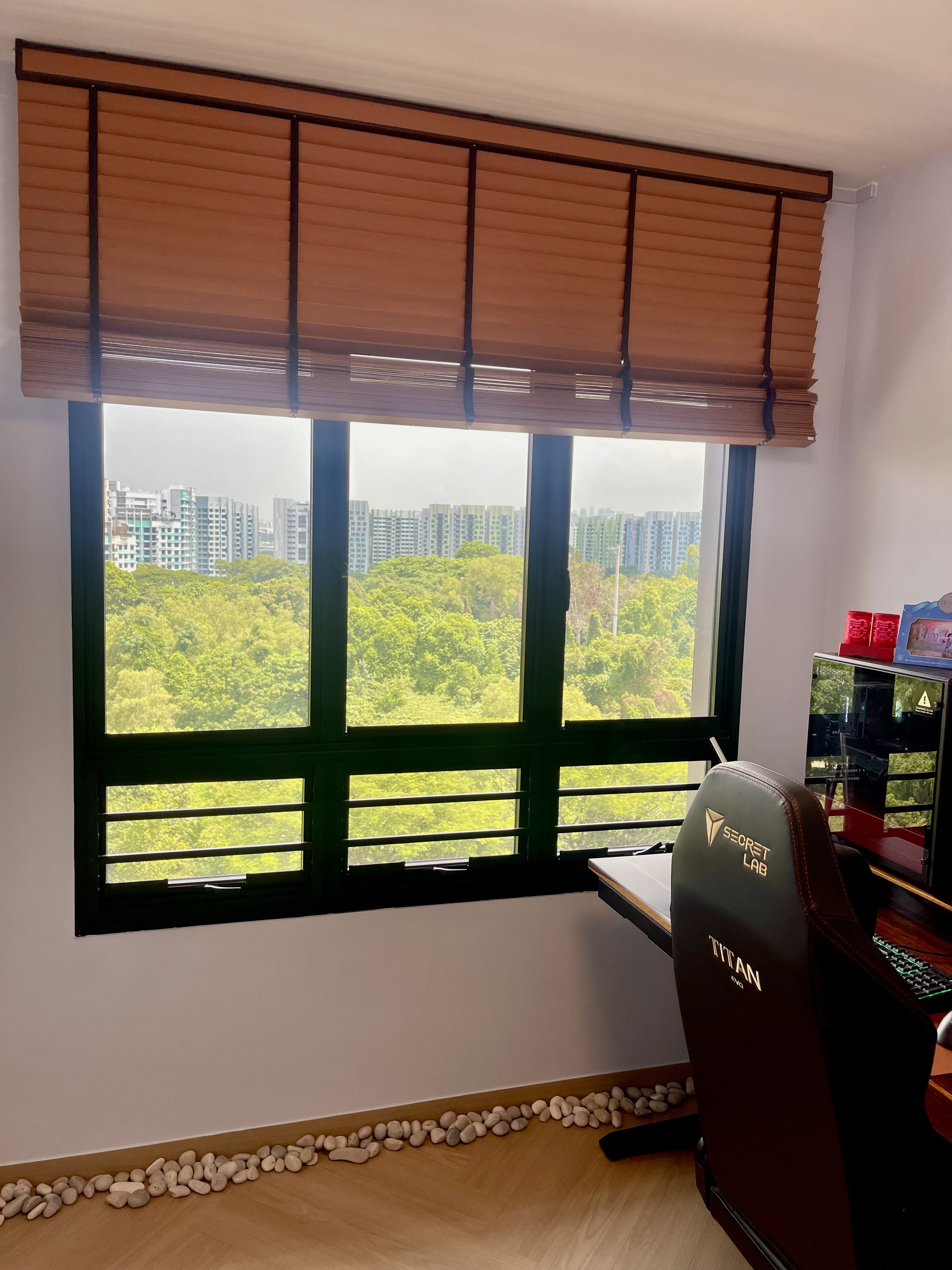 Our Minimalist Sunlit Workspace: Motorized Venetian Blinds & Greenery - Large window with wooden blinds, green trees outside