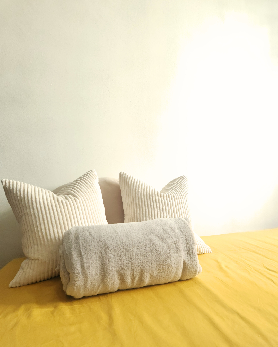 Personal Touches: Bringing Warmth to Our Guest Room - Cream and white striped pillows, yellow bedspread, soft and cozy
