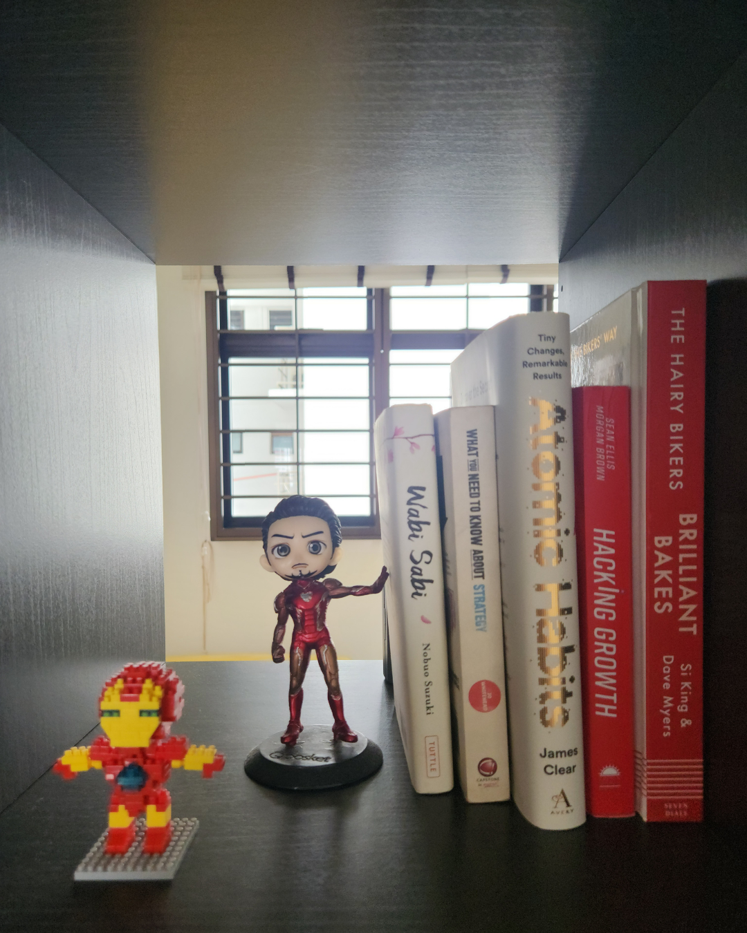 Personal Touches: Bringing Warmth to Our Guest Room - Iron Man and Iron Man figurine on dark wooden shelf, Iron Man and Iron
