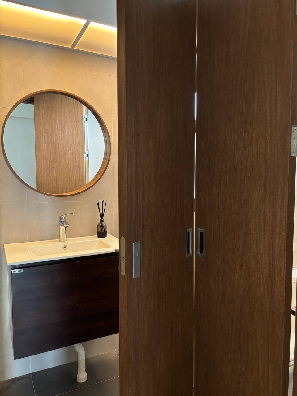 Resort style Bathrooms with HDB fittings under $2.8k - Wooden bathroom vanity, round mirror, white sink, black faucet, modern