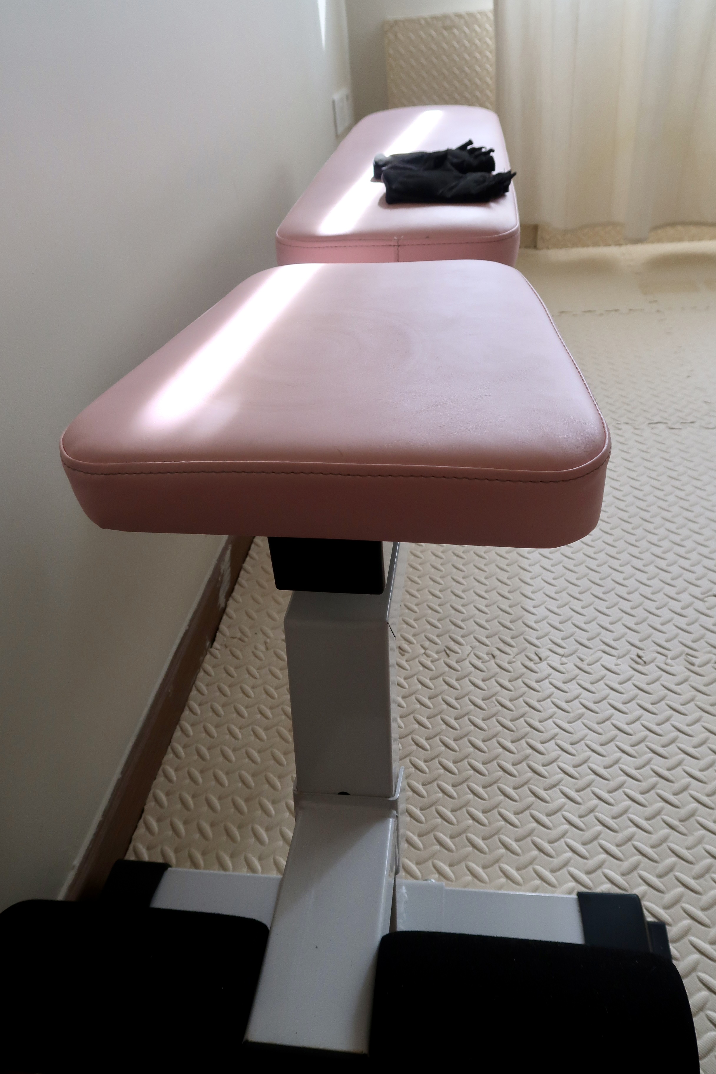 Under $1000 Home Gym: Versatile Gym Setup with Fun Colours! - Pink padded examination table, white textured floor, black