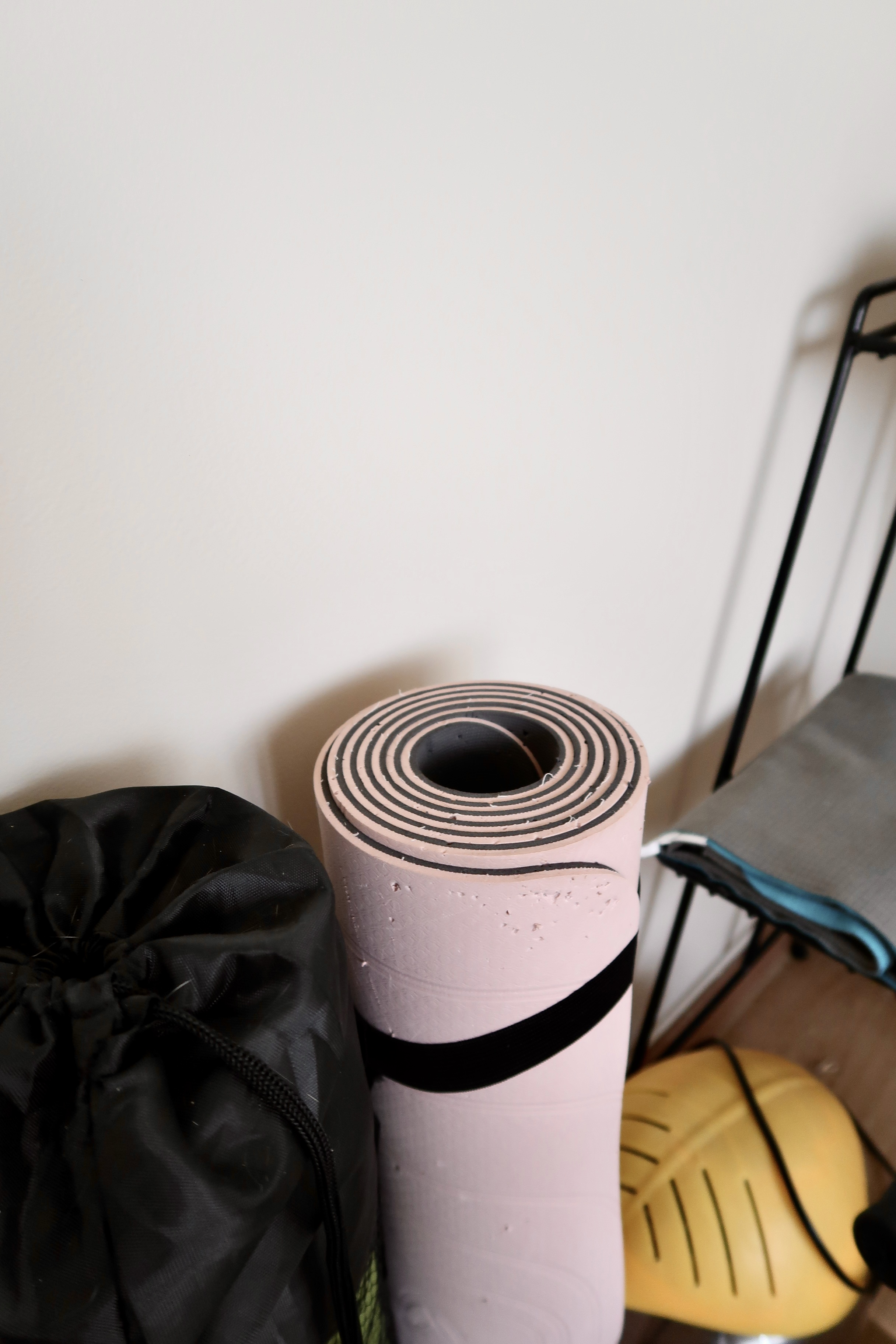 Under $1000 Home Gym: Versatile Gym Setup with Fun Colours! - mattress, rolled-up sheets, black bag, yellow helmet, black