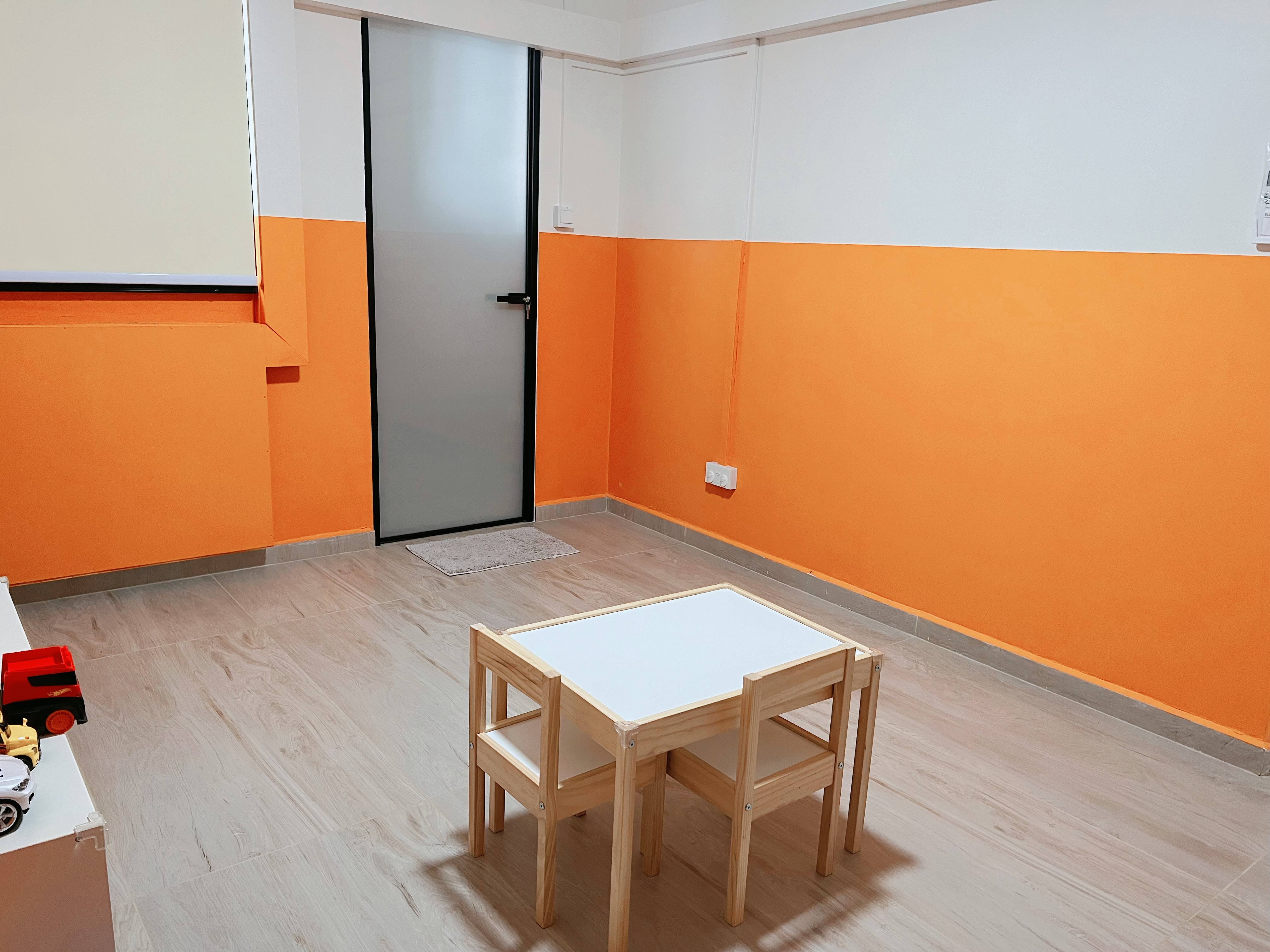 Playroom Pop: Bold Orange and a Rainbow of Fun!  - Orange and white walls, wooden floor, small table with chairs, toy