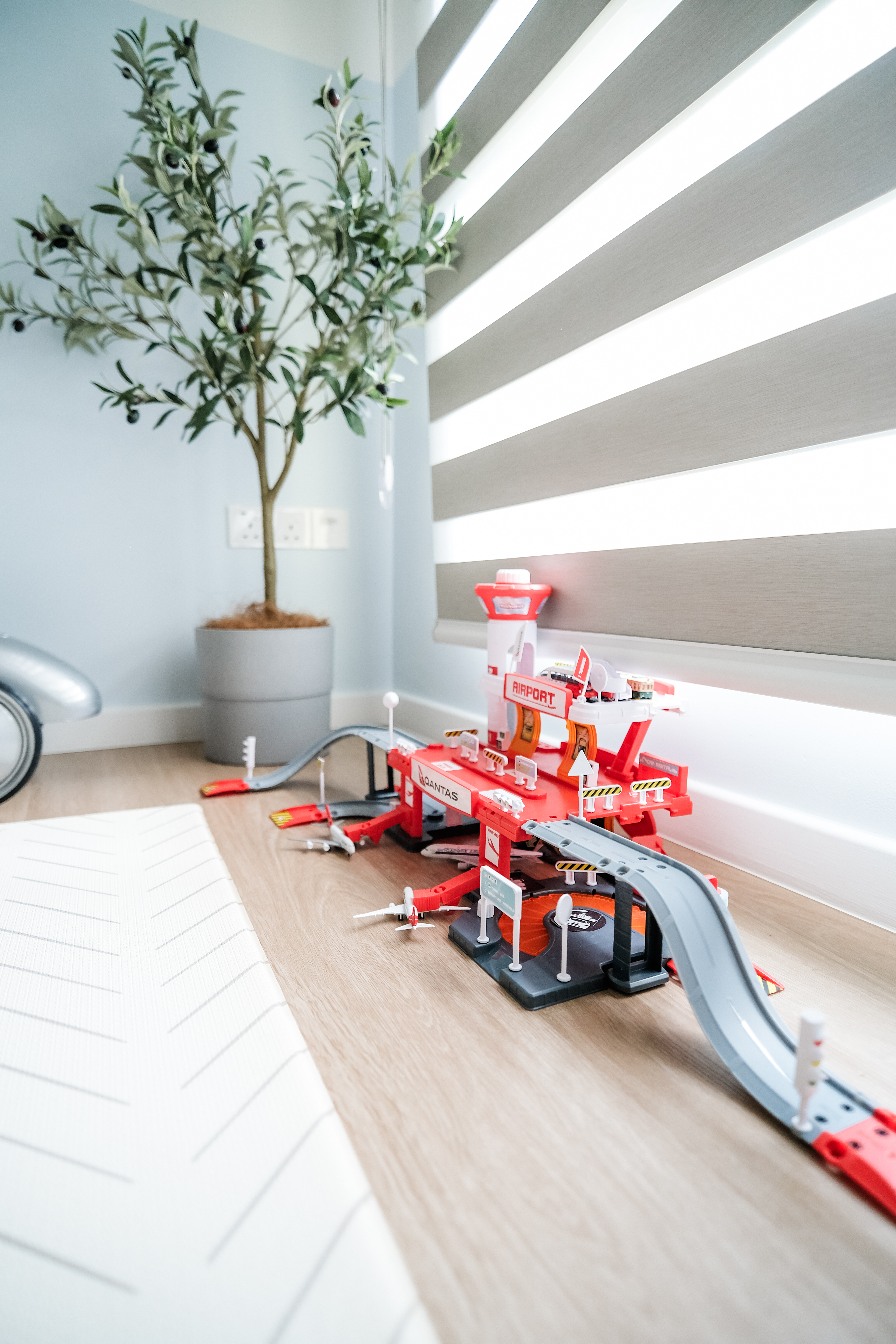 Playroom Design with Loose Furniture for Maximum Space and Flexibility - Miniature toy airplane on track, red and white color