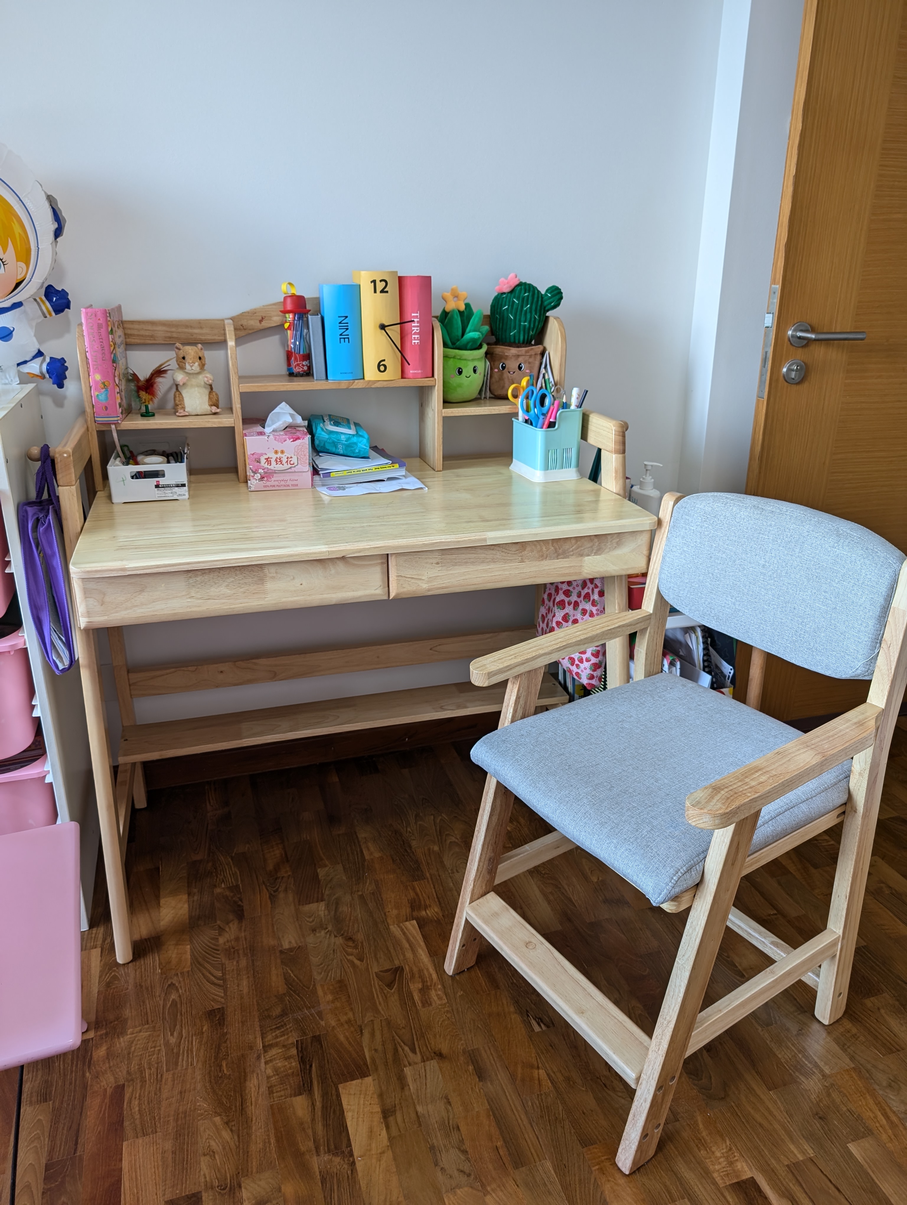 A pink room for lil miss pink 💕 - Wooden desk with various items, including books, a mouse, scissors, and stationery, placed