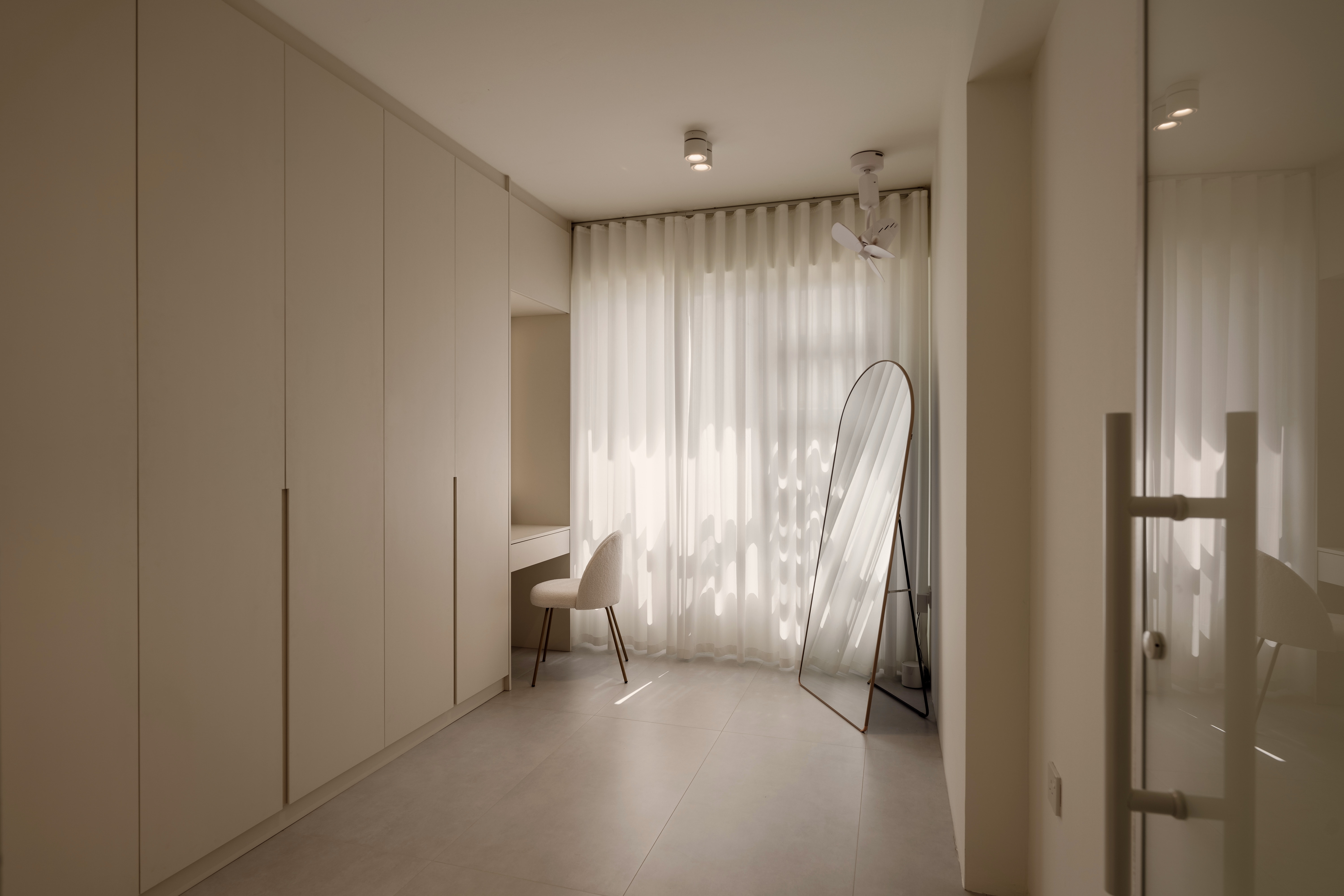 Designing My Ideal Wardrobe And Vanity Space - Minimalist room with beige cabinets, soft natural light streaming through