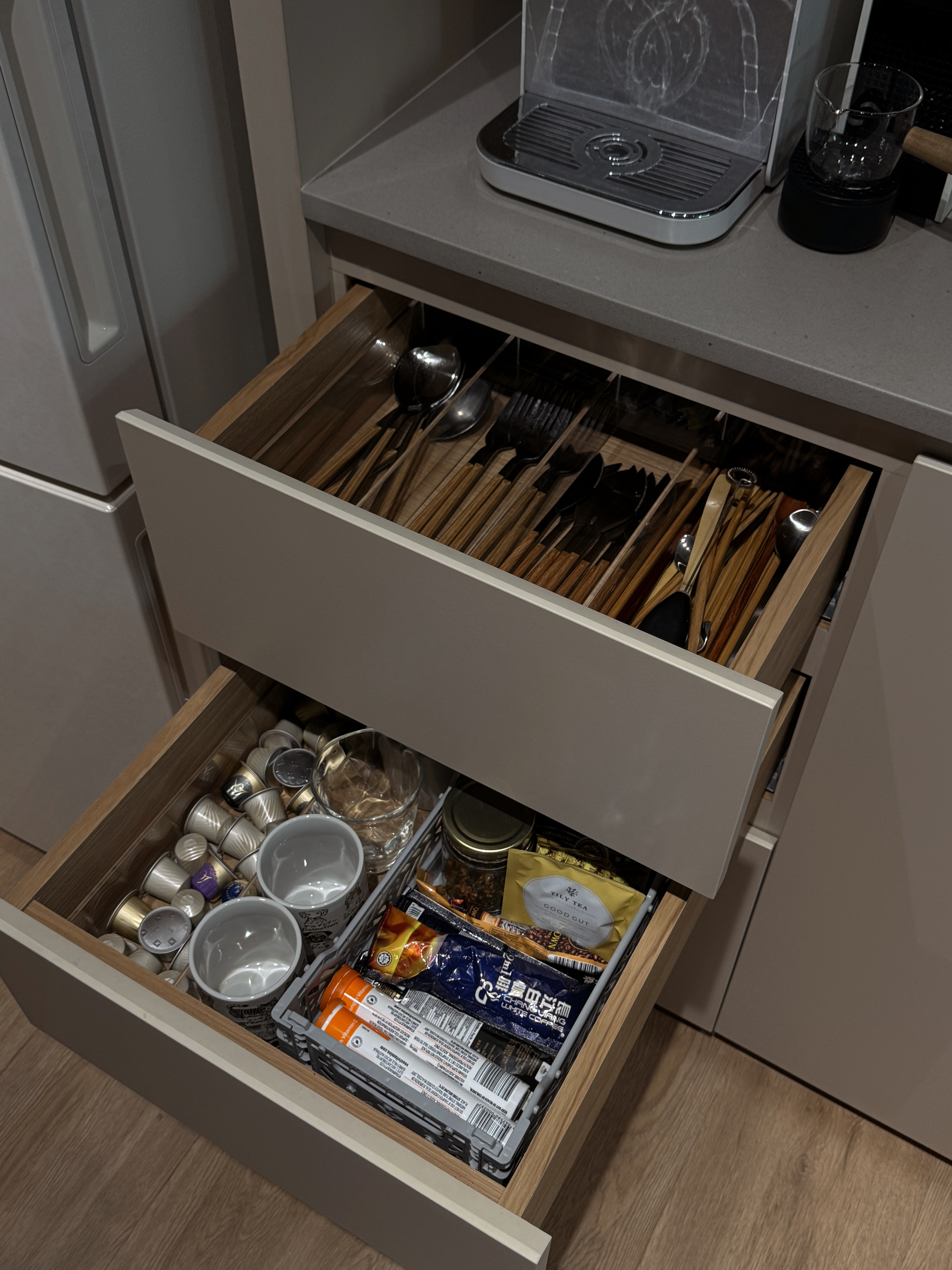 Our Kitchen Renovation Journey: FAQs and Lessons Learned - Wooden kitchen drawer, open, neatly organized, stainless steel