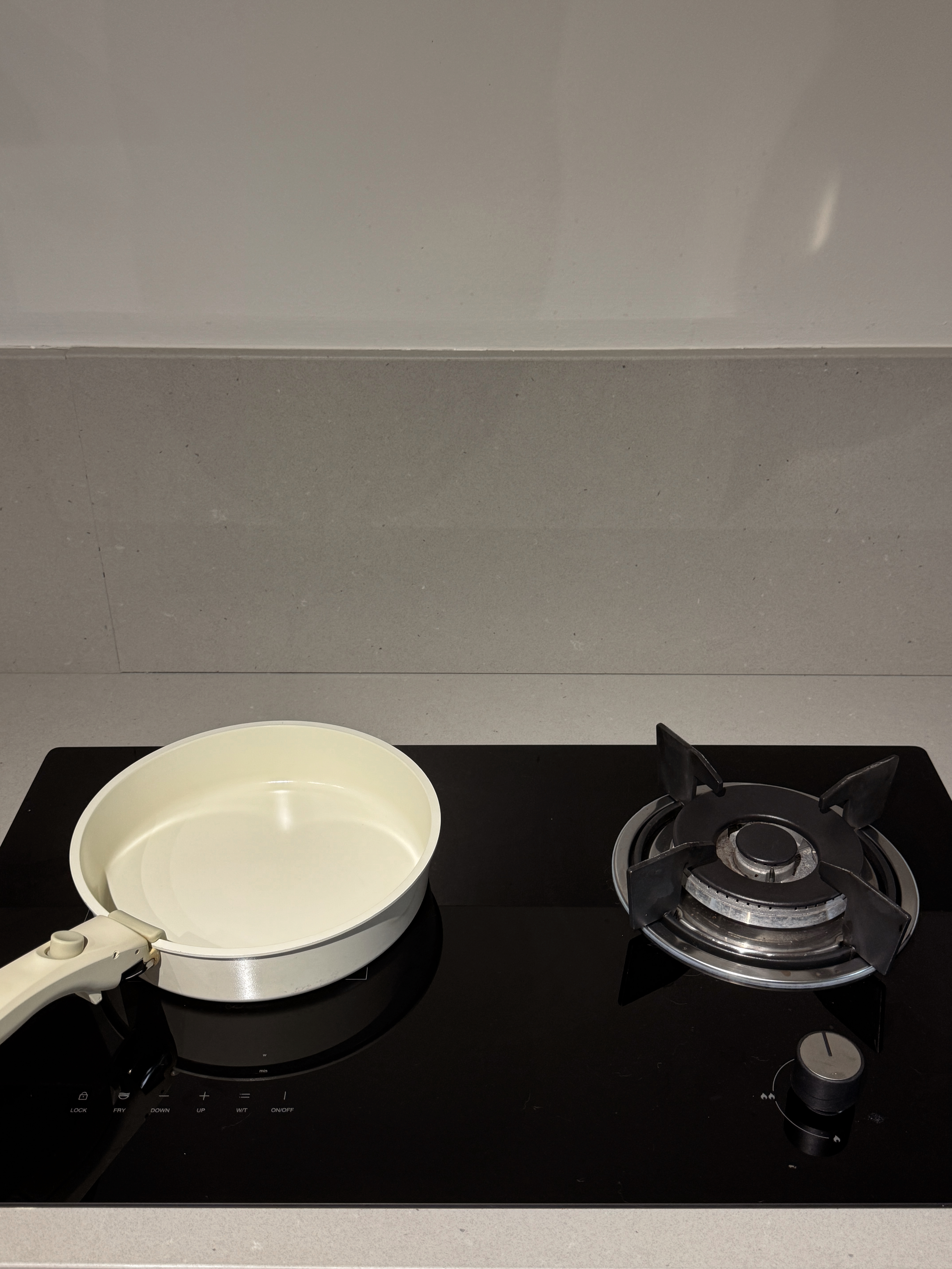 Our Kitchen Renovation Journey: FAQs and Lessons Learned - White frying pan, black stovetop, modern kitchen, black and white