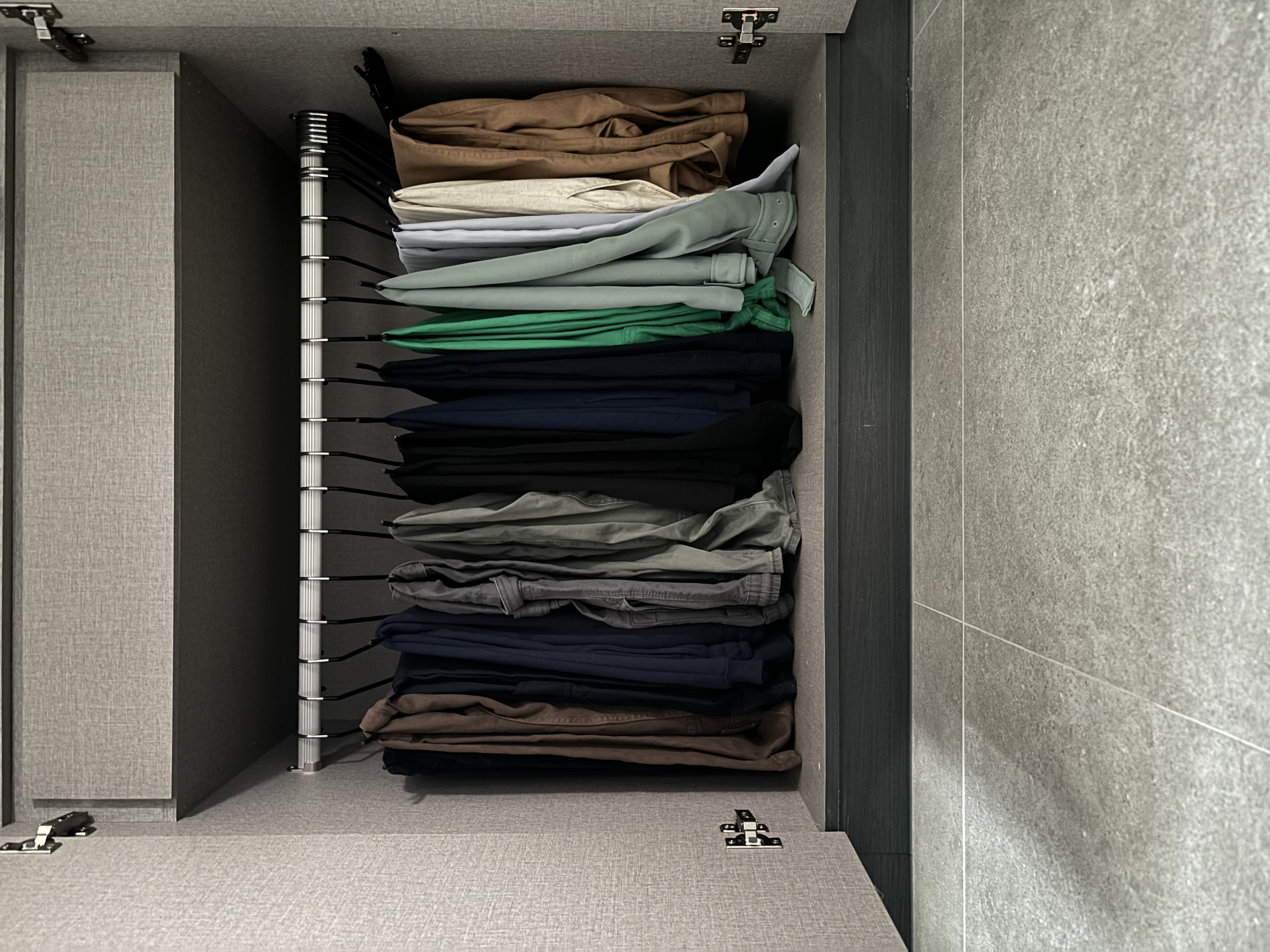 Simple home organisation tips you can try! - Gray, textured wall, open closet, neatly folded clothes, black metal rack