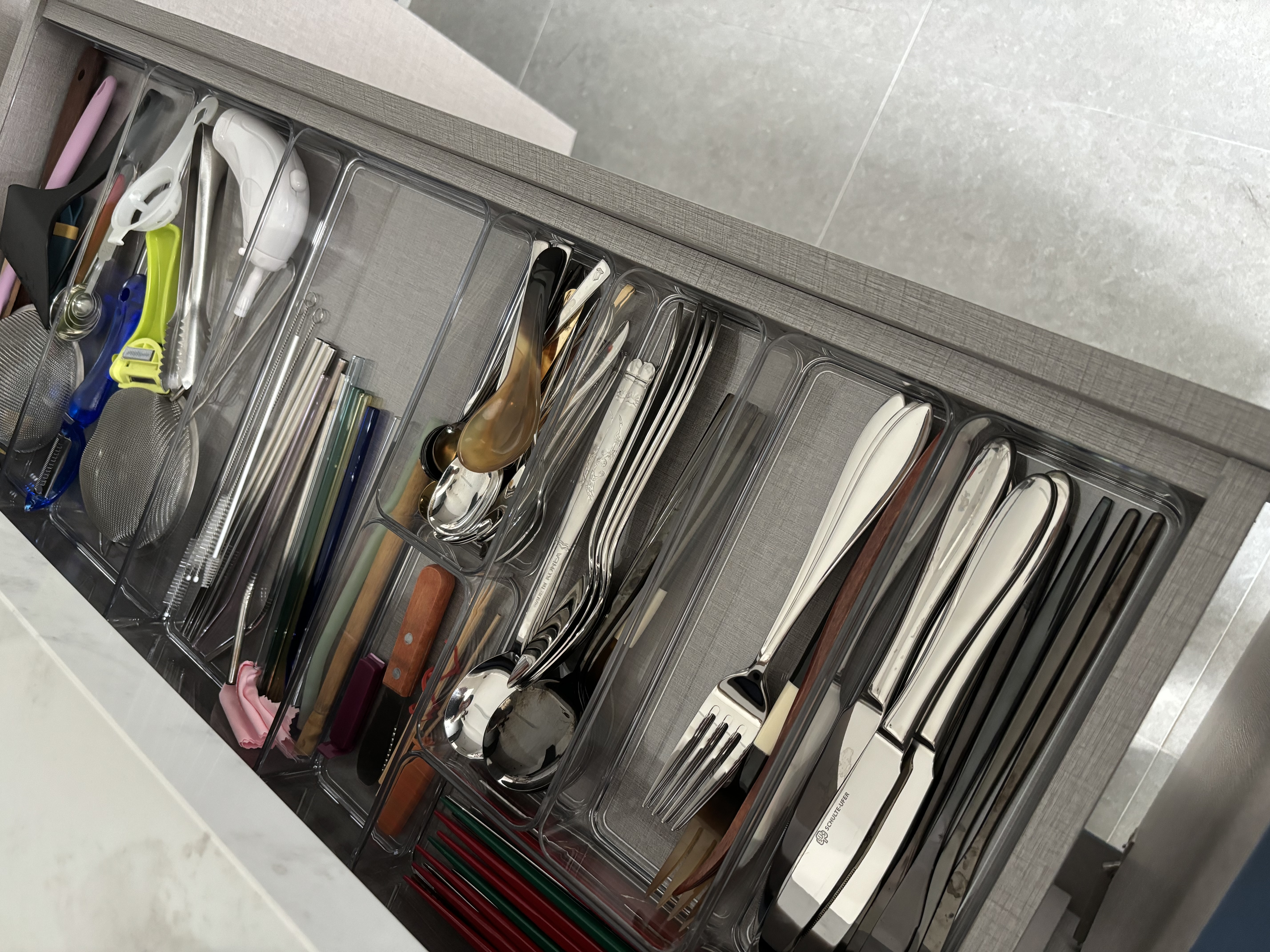Simple home organisation tips you can try! - Clear glass storage bins, neatly organized utensils, stainless steel knives