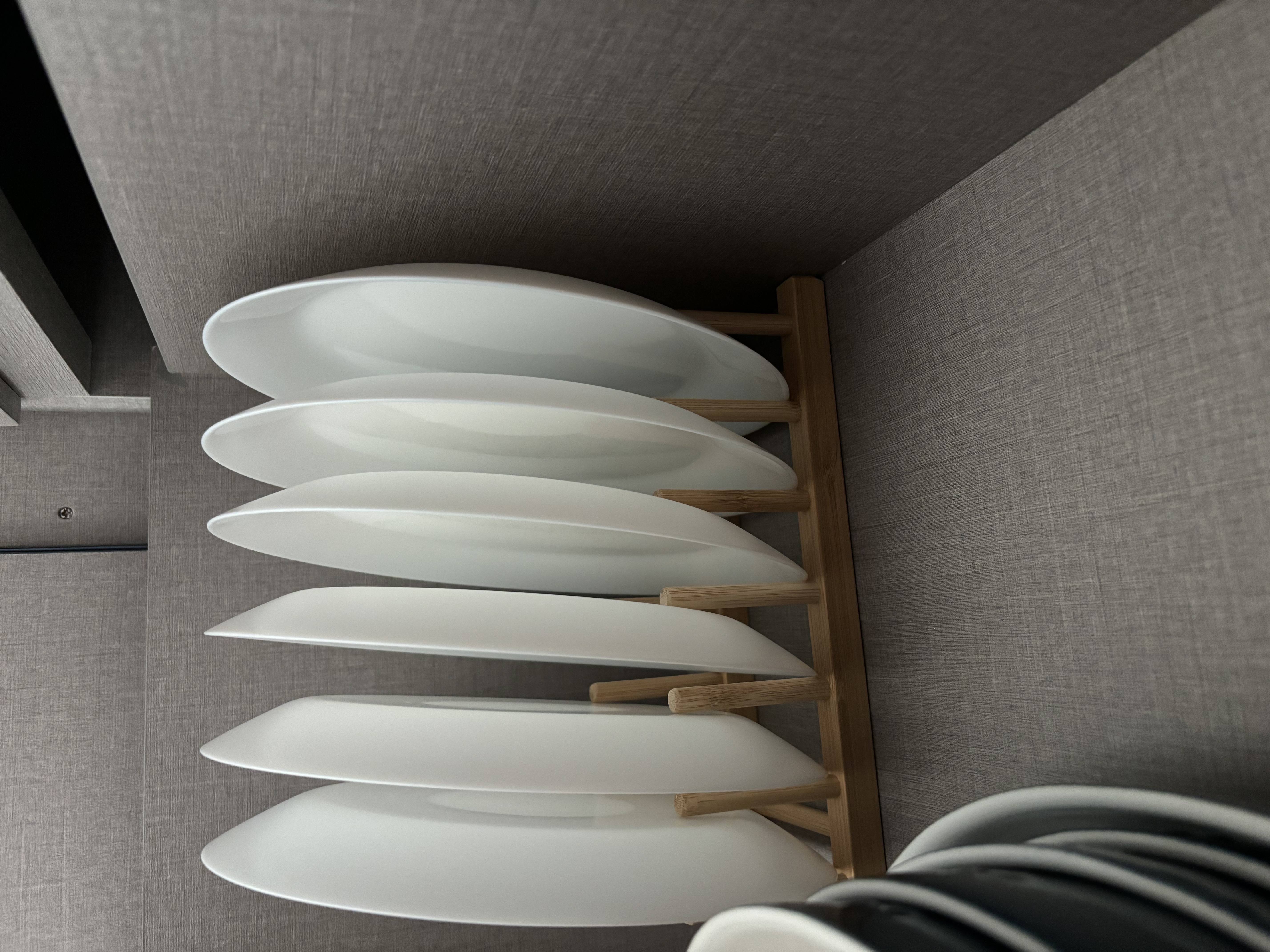 Simple home organisation tips you can try! - White ceramic plates, wooden dish rack, minimalist kitchen setting, modern