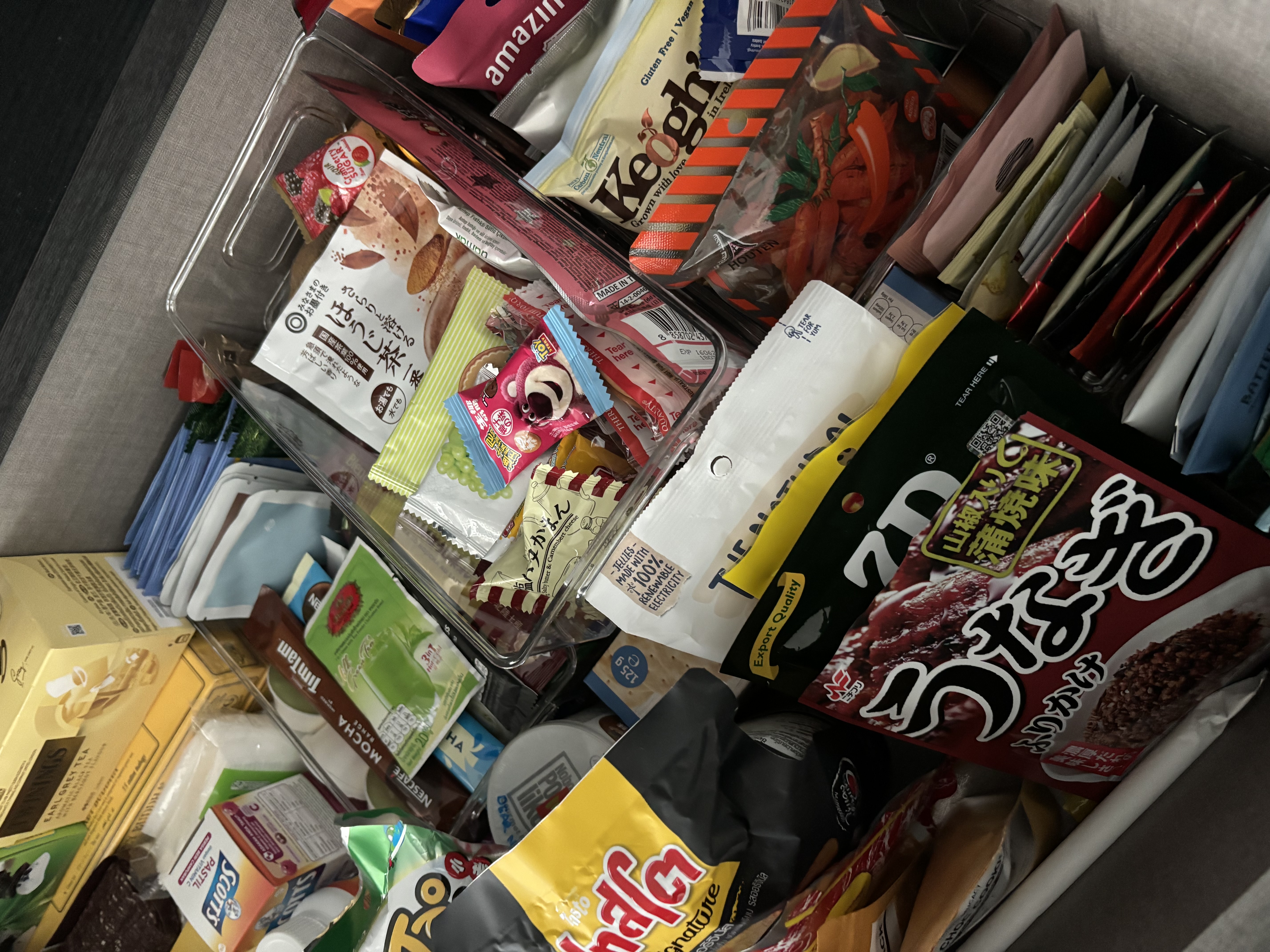 Simple home organisation tips you can try! - Various snack packages in a grocery bin, Mixed assortment of packaged foods