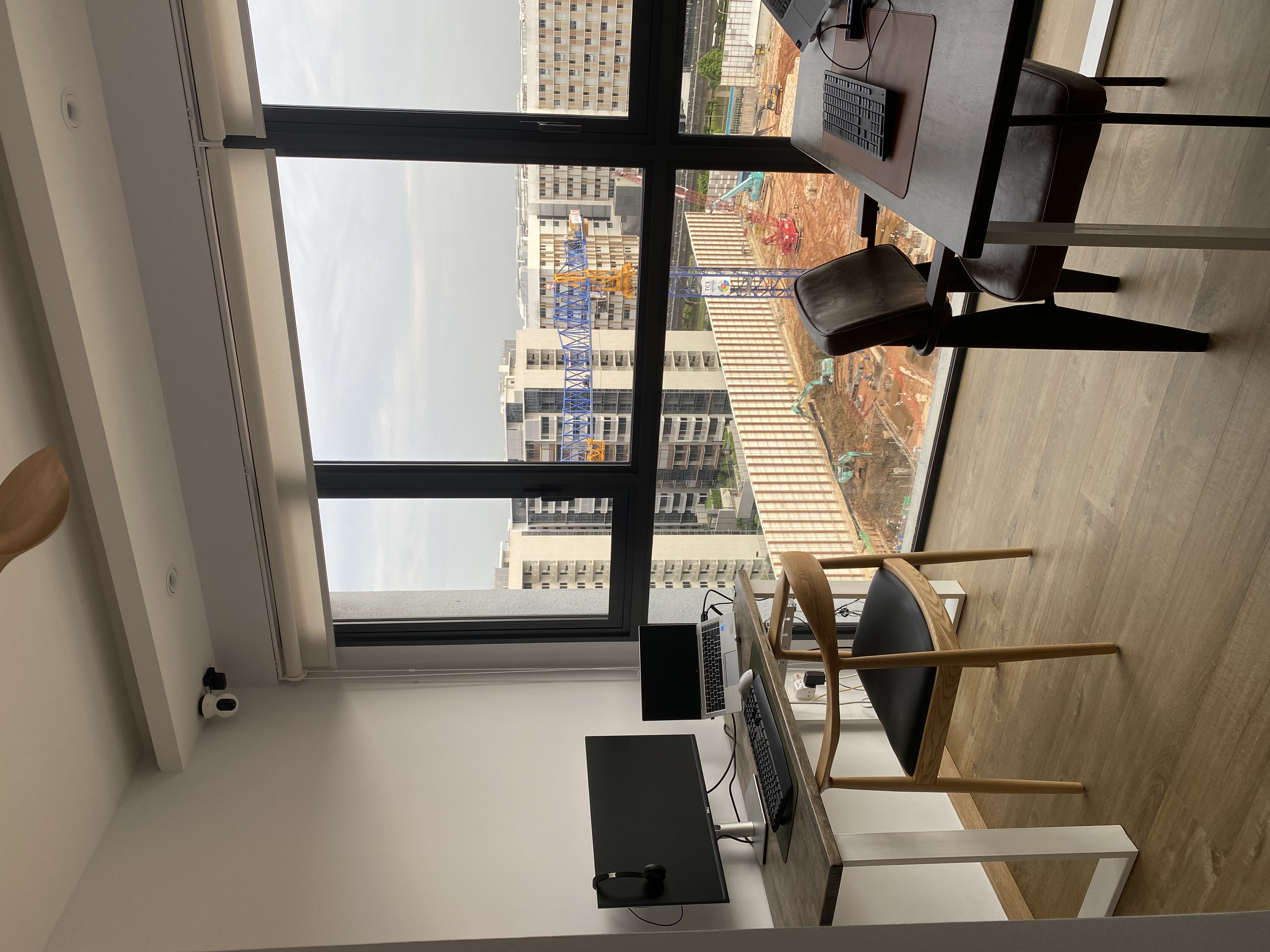 Minimalist work room for 2 with no built-ins - Modern office space, large window, construction site view, indoor plant