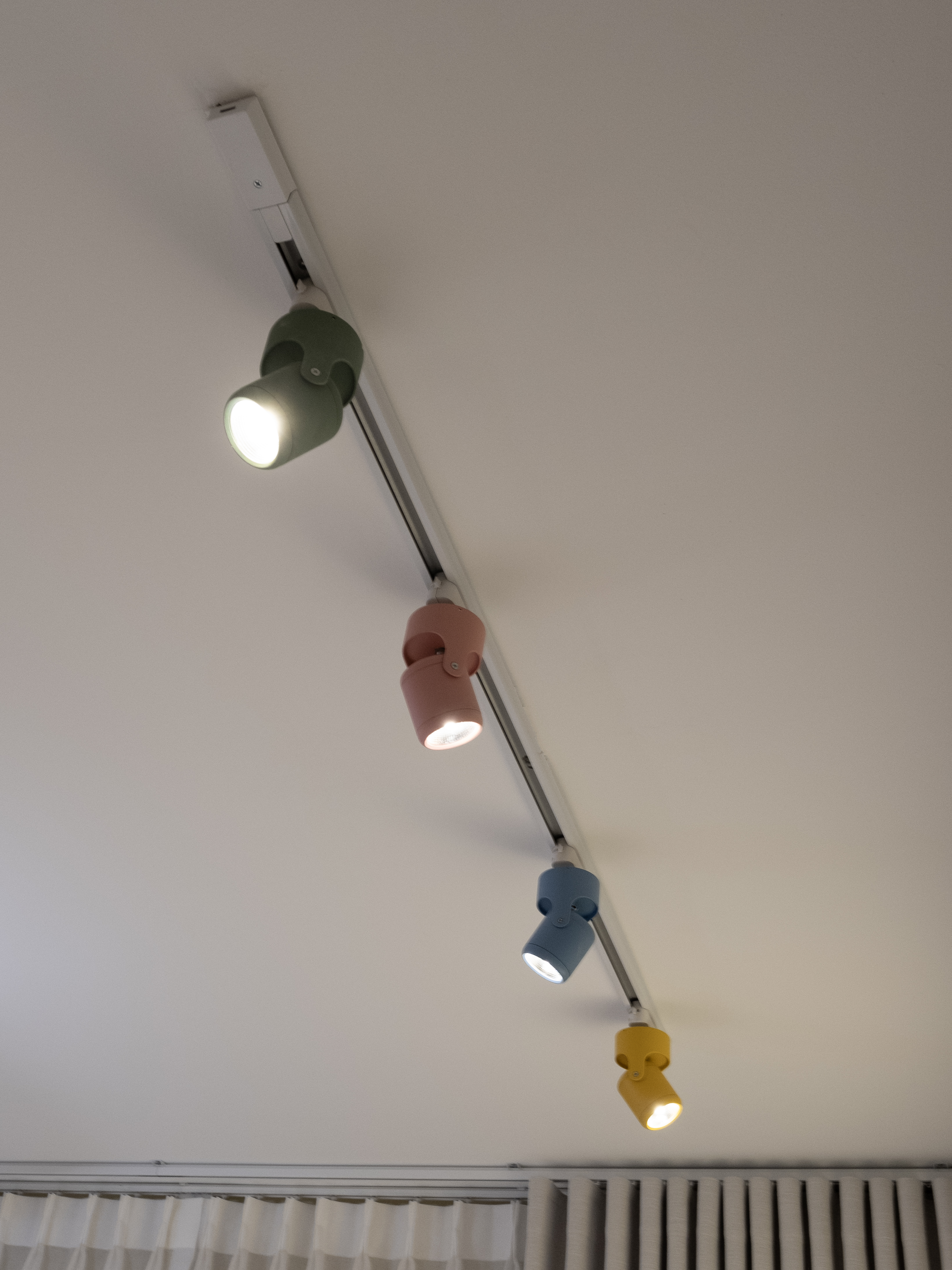 Whimsical Pastel Rainbow & Dino-Themed Kids’ Room - Modern ceiling light fixture with three different colored bulbs