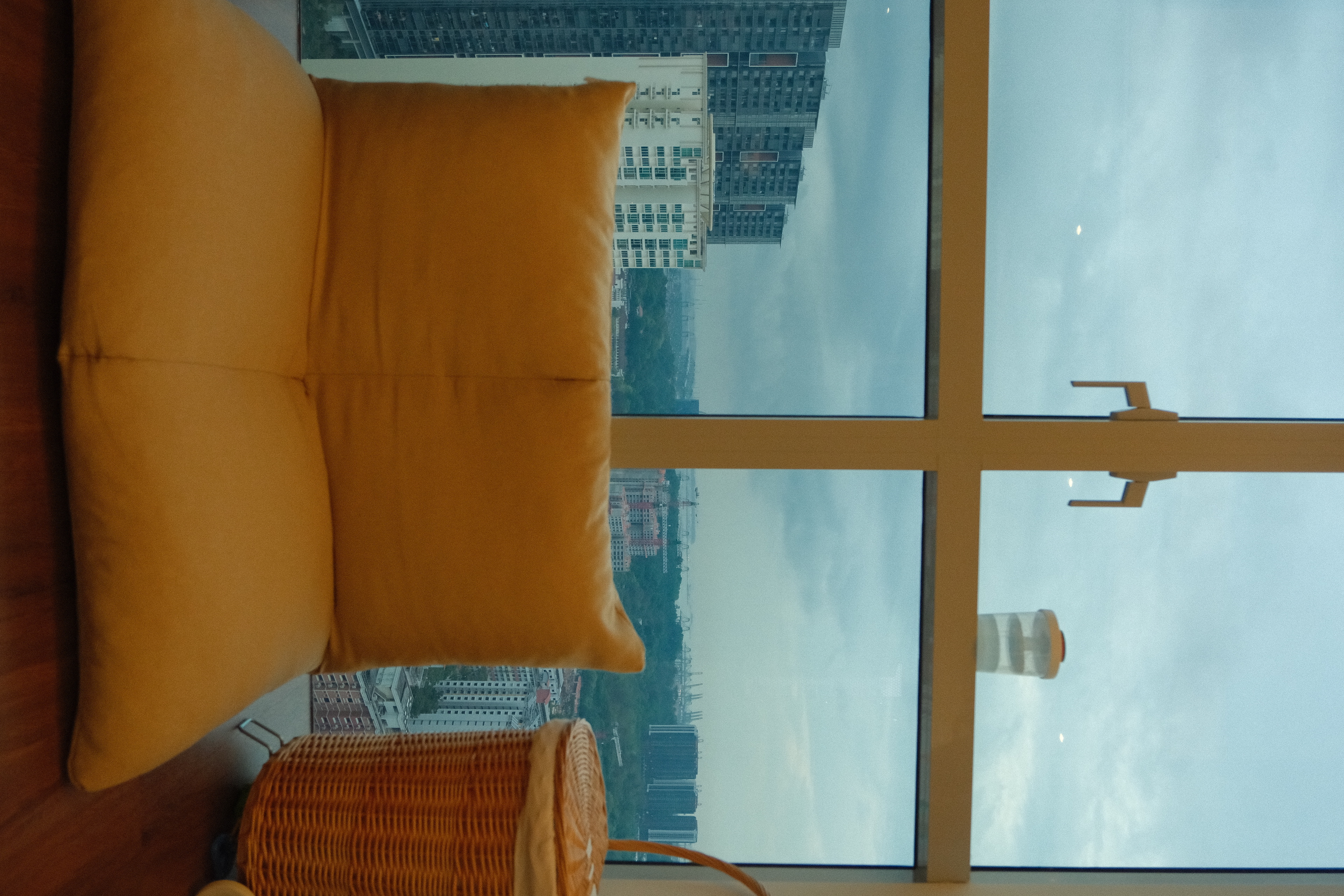 Study with a view! - Large mustard yellow cushions, cityscape view, tall buildings, overcast sky, modern interior, large