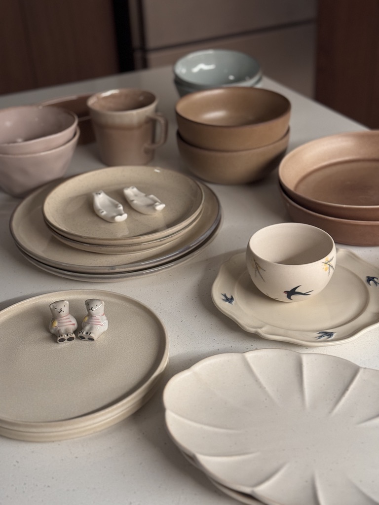 What we've learnt about hosting - muted earth tones, ceramic plates, bowls, and cups, minimalist design, ceramic bear