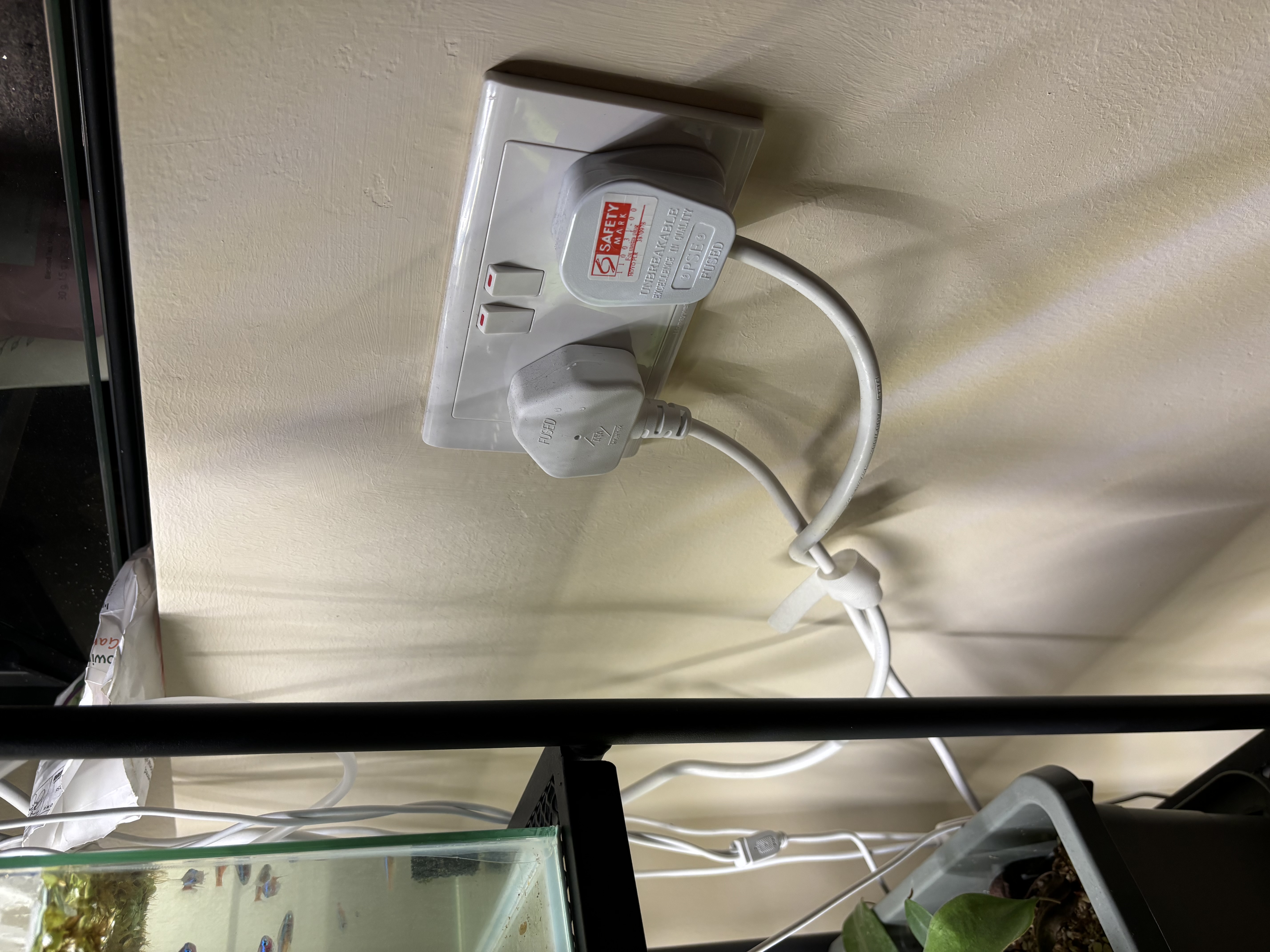 Our green corner: A space-saving, DIY, plant rack!  - Safety marked by label on power outlet, fish tank in background, white