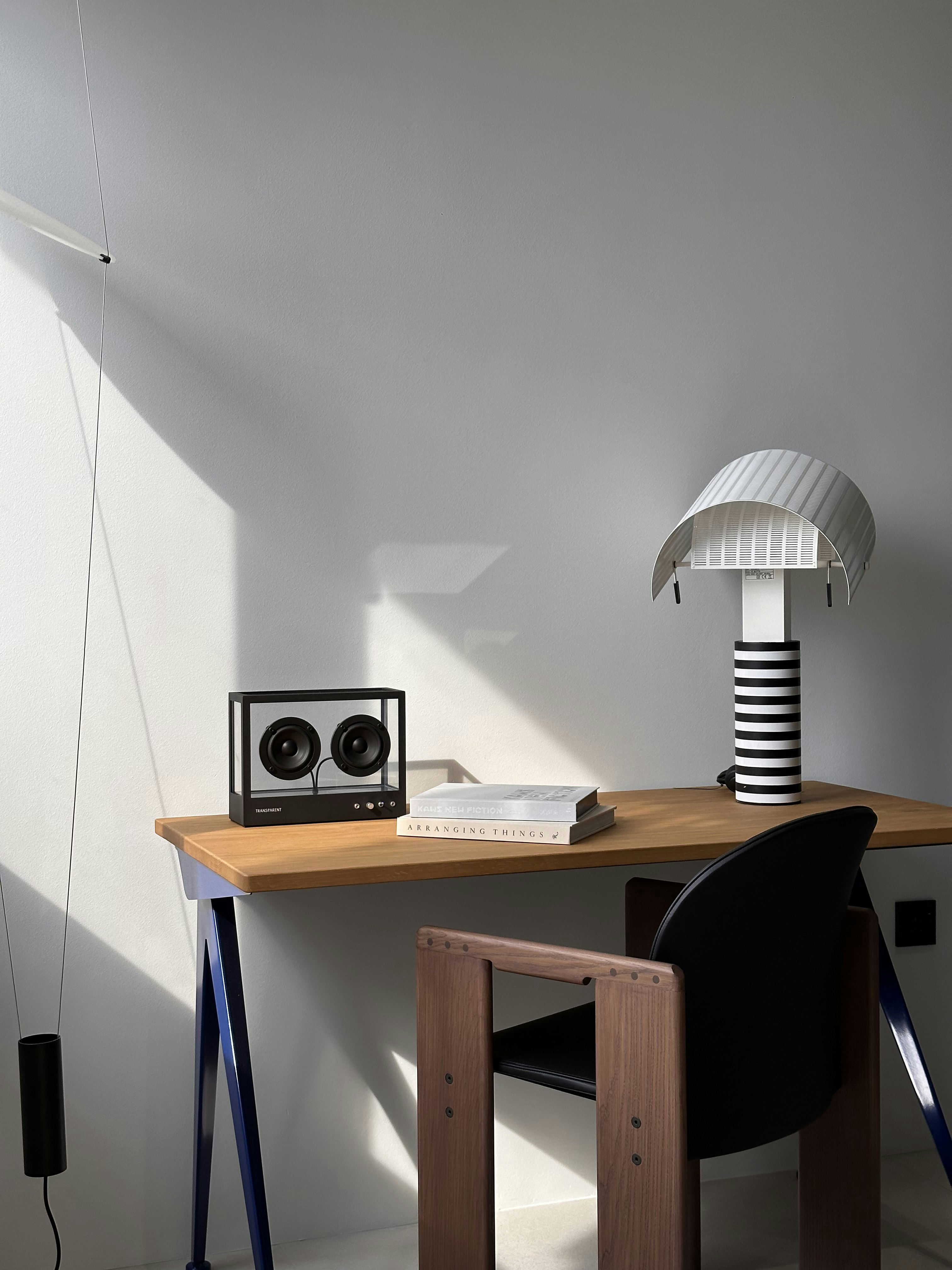 Behind the Bookshelf – Our Minimalist Study Area - Modern minimalist desk, sleek black speaker, transparent speaker
